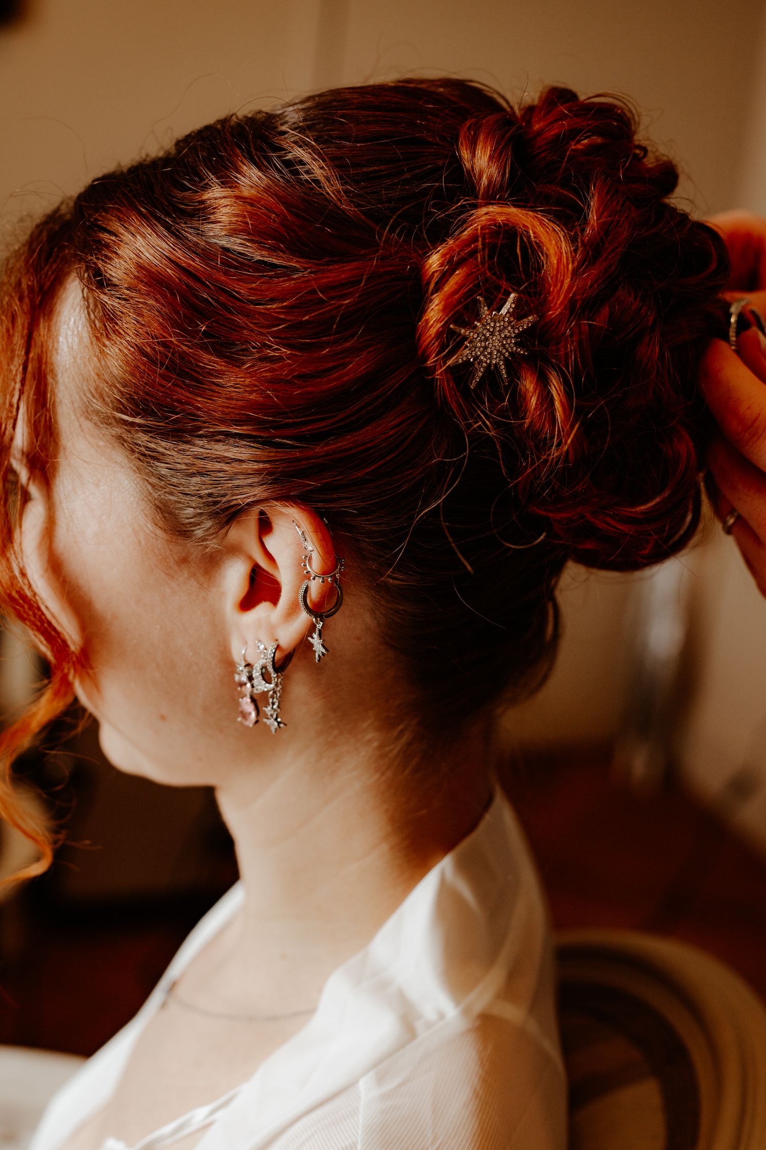 Gros plan sur la coiffure de la mariée et son profil pendant les préparatifs du mariage. Détails mariage.
