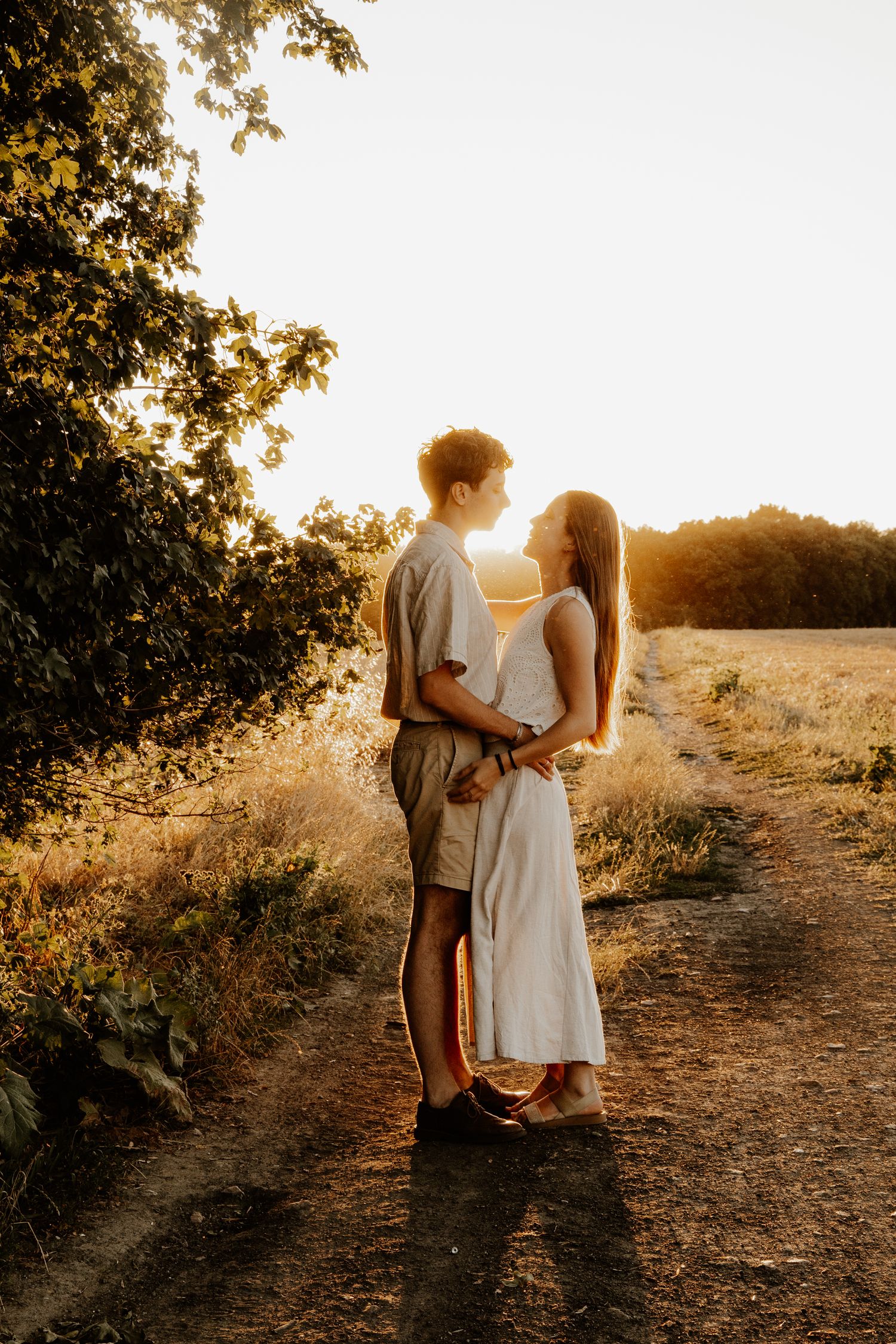 photo de couple au couché de soleil dans les champs