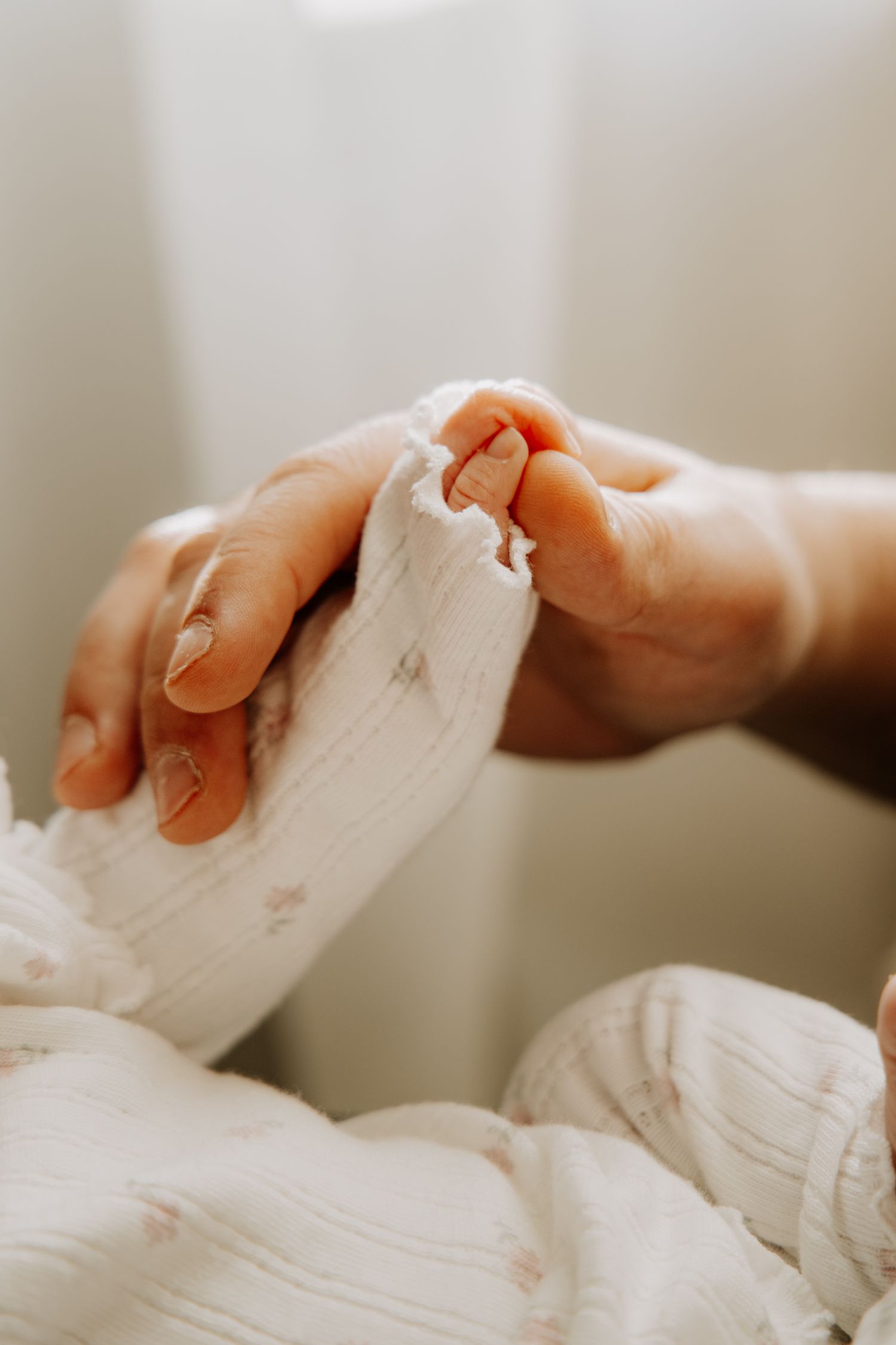 détails des mains d'un papa dans la main de son nouveau-né
