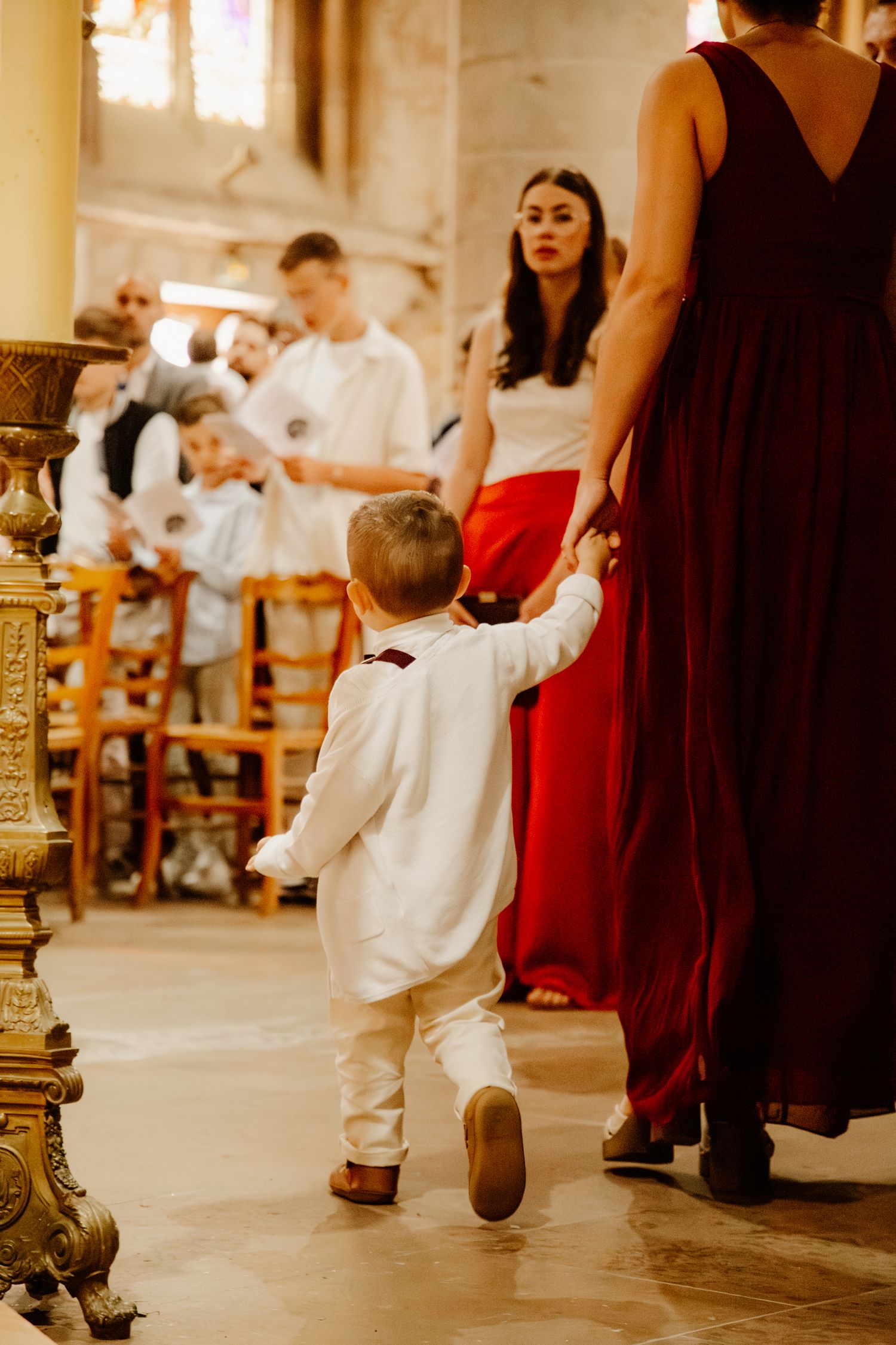 maman qui tien dans la main son fils pendant son baptême