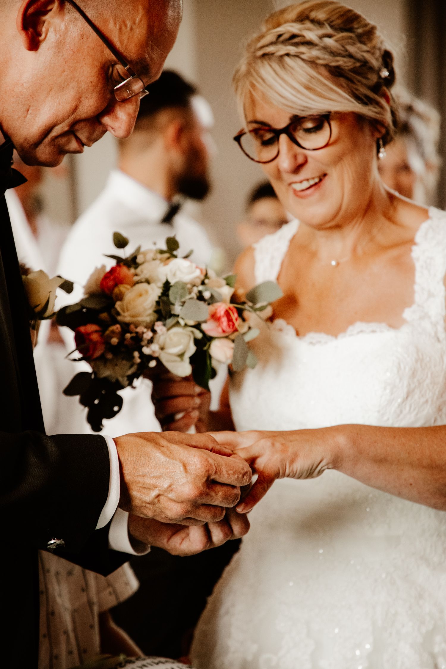 Échange des alliances au doigt des mariés lors de la cérémonie de mariage civil à la mairie. Photographe de mariage.