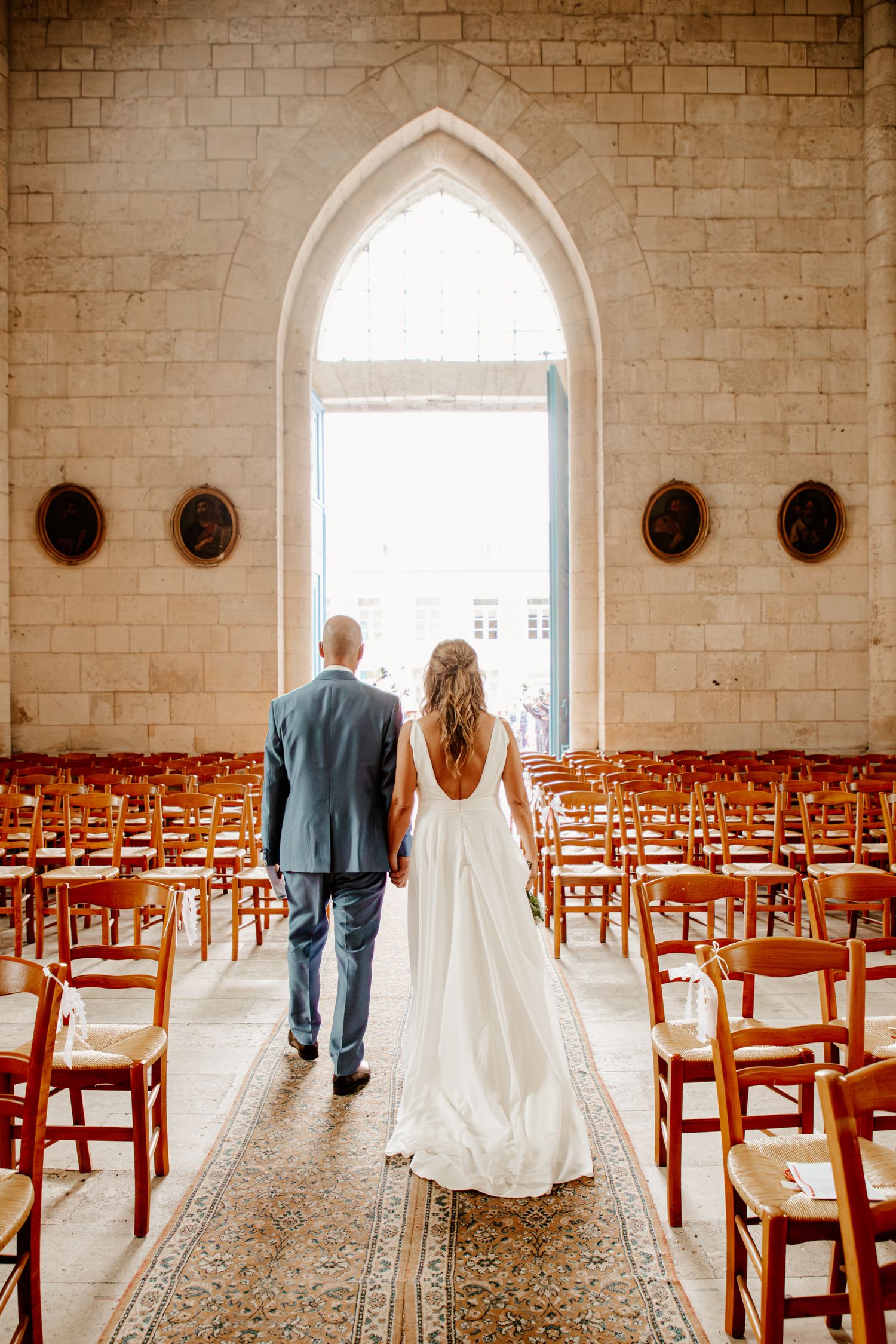 Couple de mariés s'embrassant dans l'allée centrale d'une église après leur cérémonie de mariage. Photo d'art.