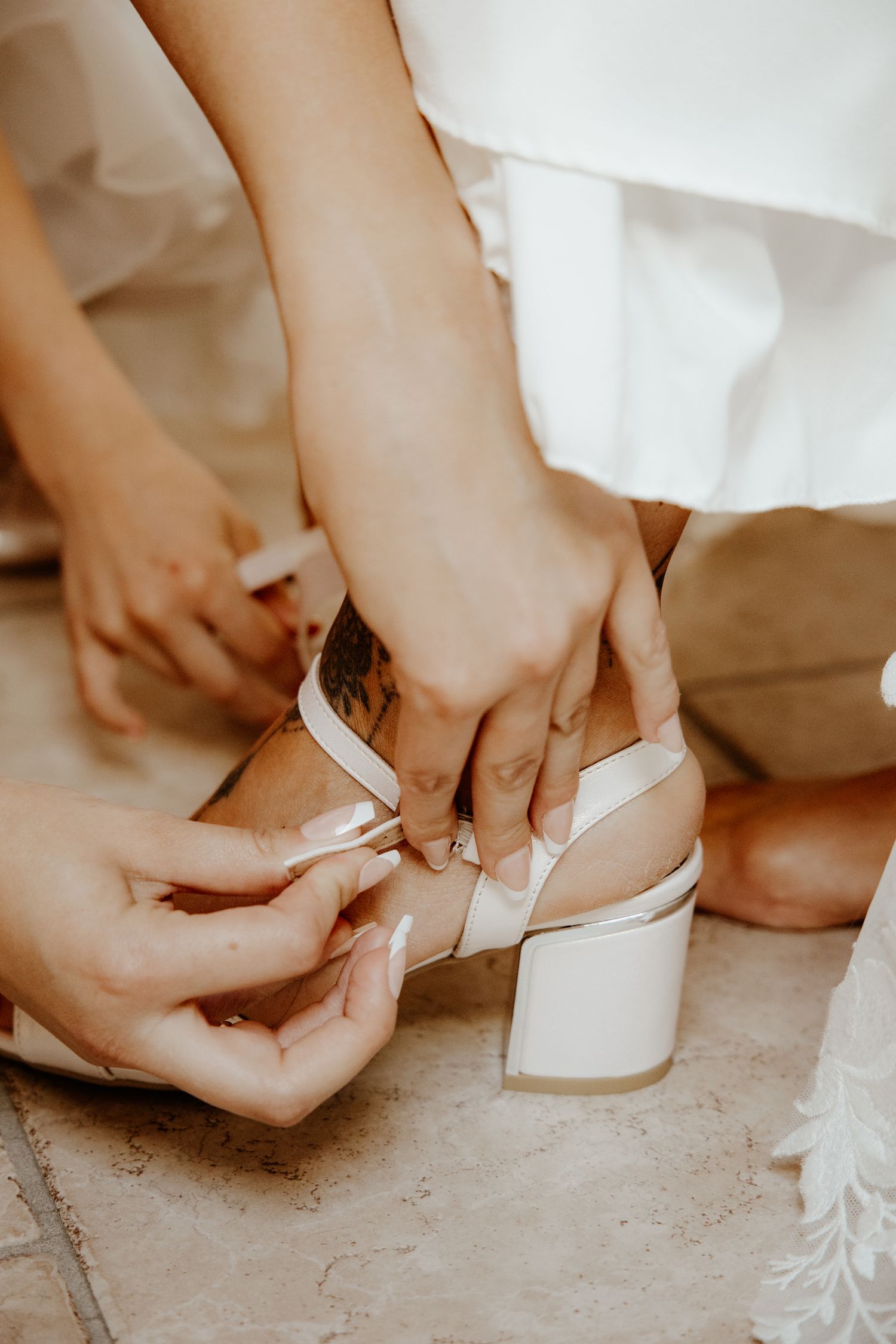 Détail des préparatifs de la mariée en train d'ajuster sa chaussure de mariage à talon.