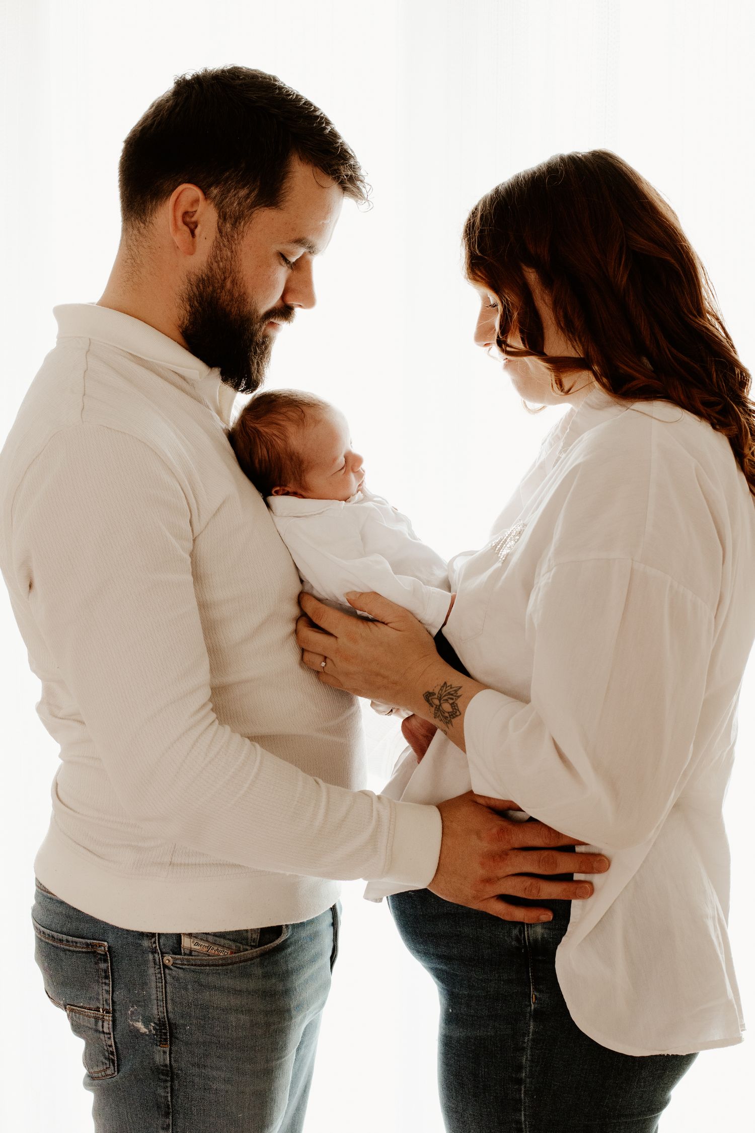 séance photo naissance en studio avec une jeune couple qui vient d'être parents et leurs nouveau-né