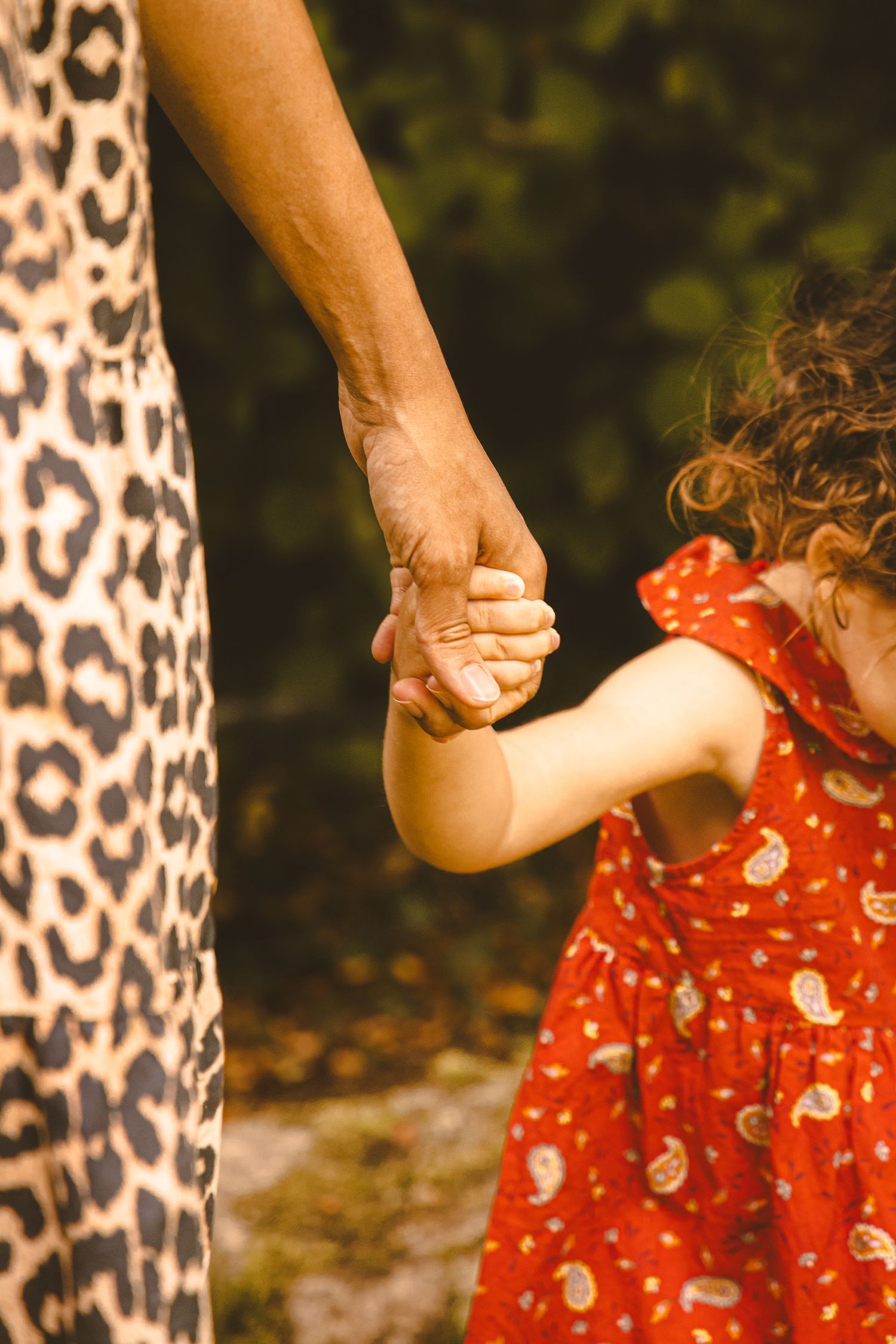 détails d'une petite fille qui prend la main de sa maman