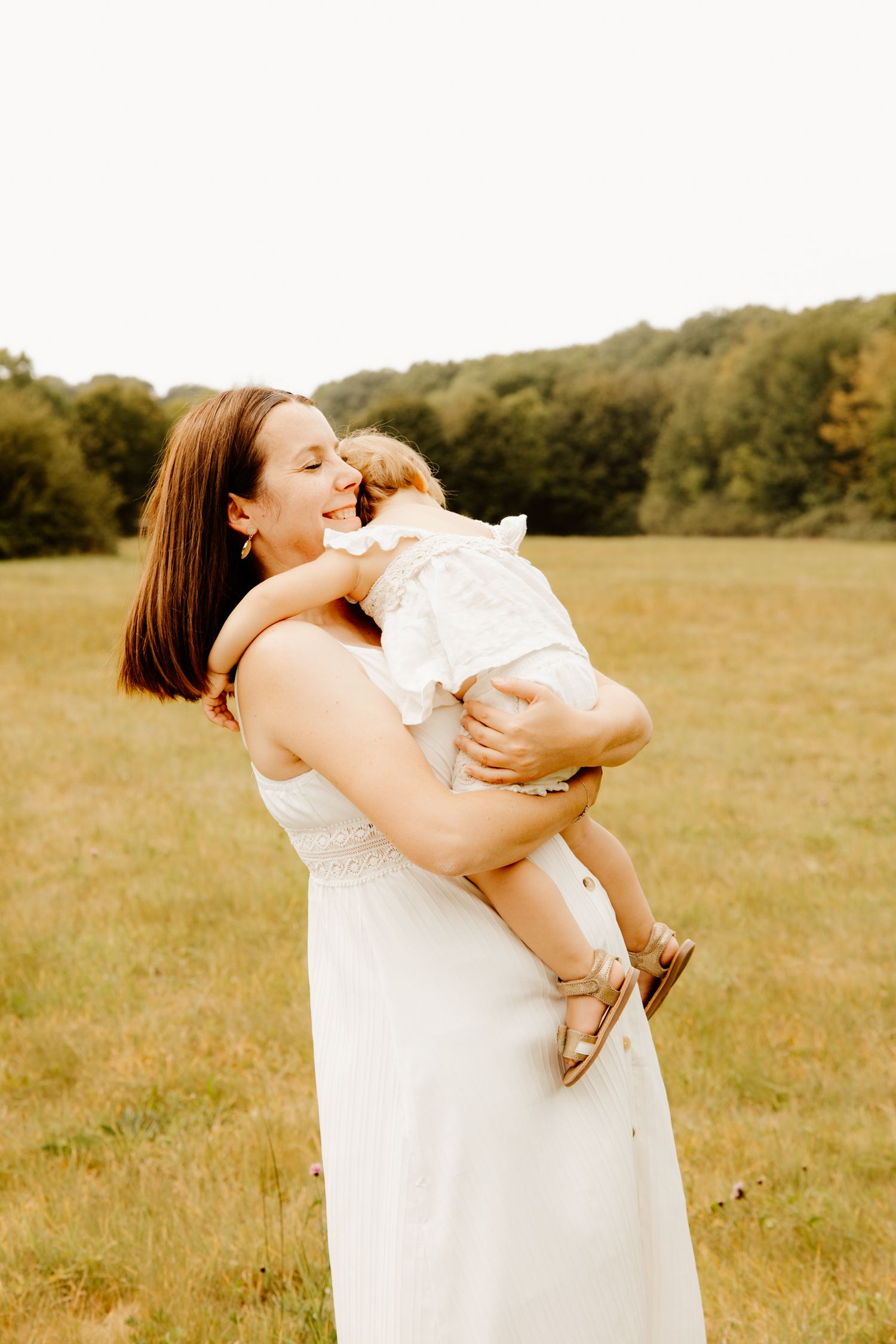 petit fille qui fait un câlin à sa maman pendant une séance photo mère et fille