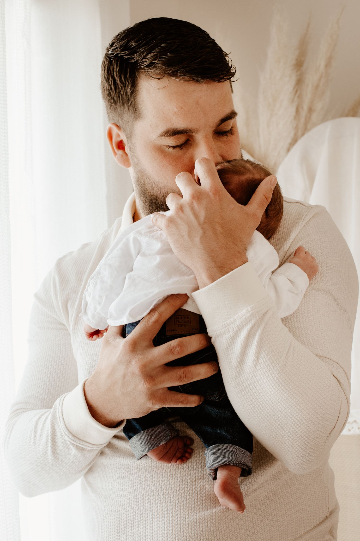 papa qui fait un câlin à son bébé pendant une séance photo naissance