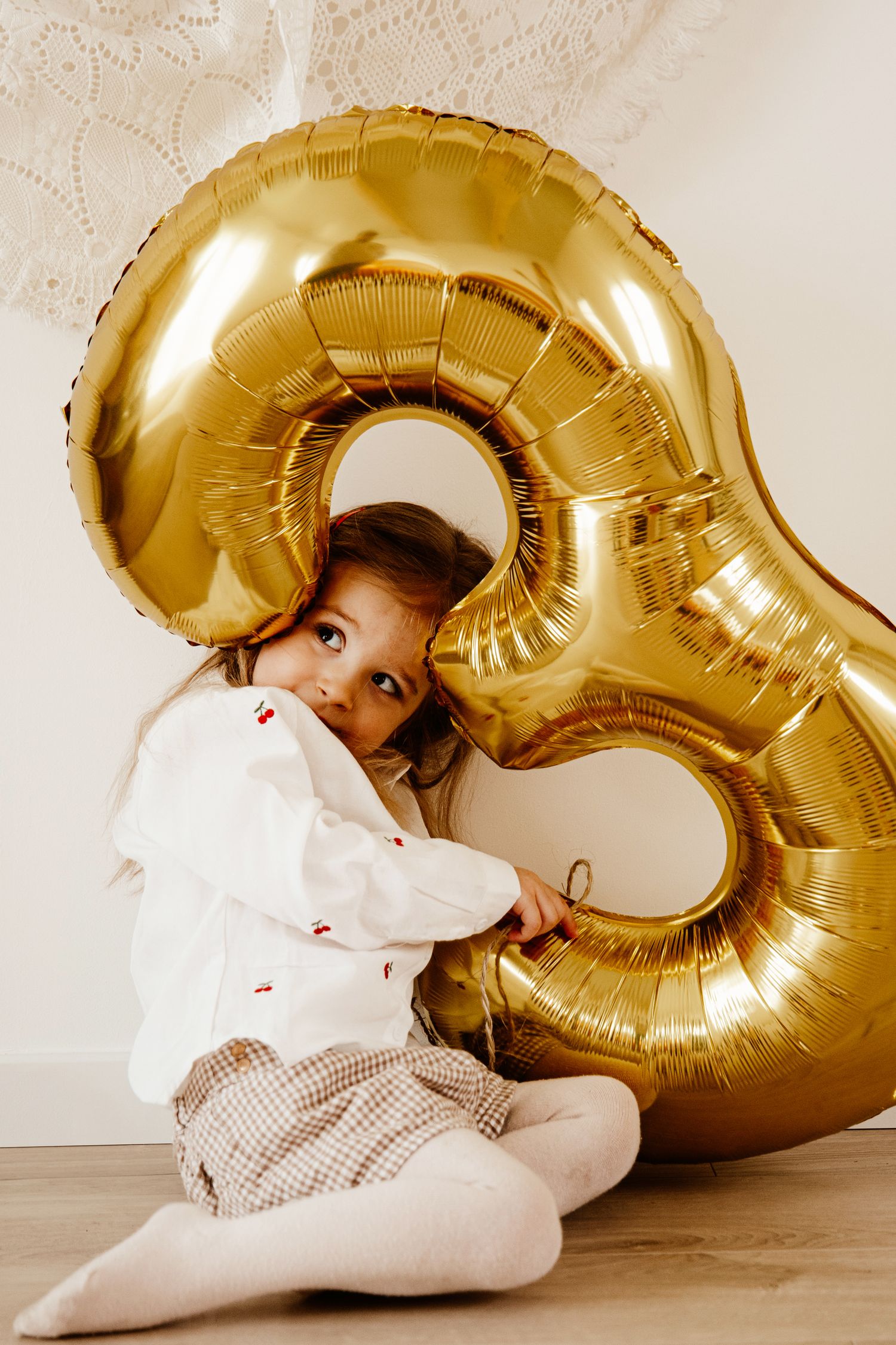 petite fille qui fait un câlin à une gros ballon 3 ans pour une séance photo de ses 3 ans