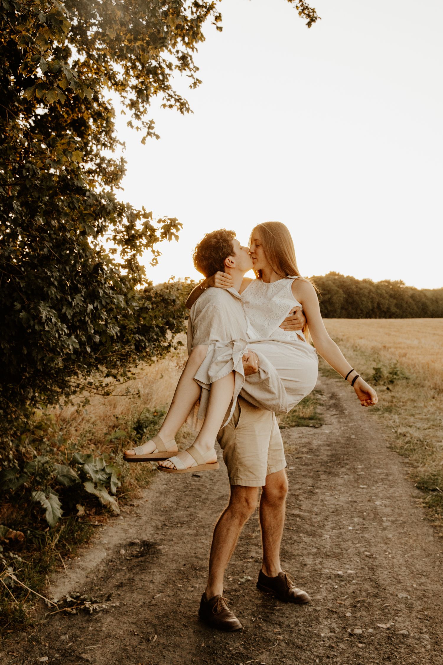 Séance photo couple romantique en extérieur, moment complice au coucher du soleil.
