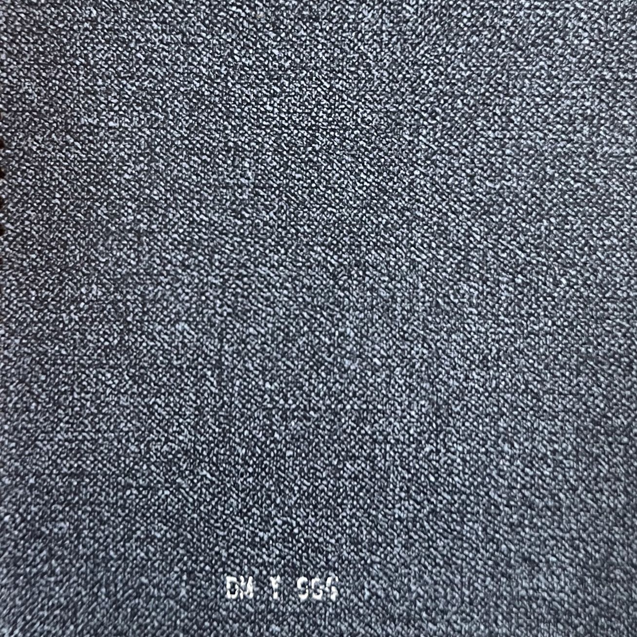 Close-up of dark blue-gray textured fabric material with fine woven pattern, labeled DM Y 560.