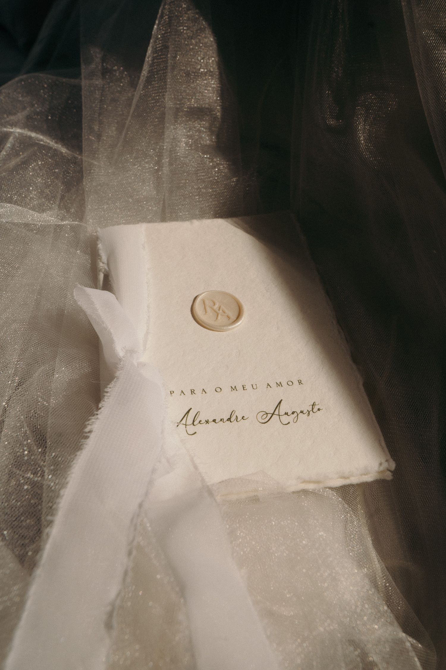 Elegant wedding vow booklet with wax seal reading Para O Meu Amor on white fabric.