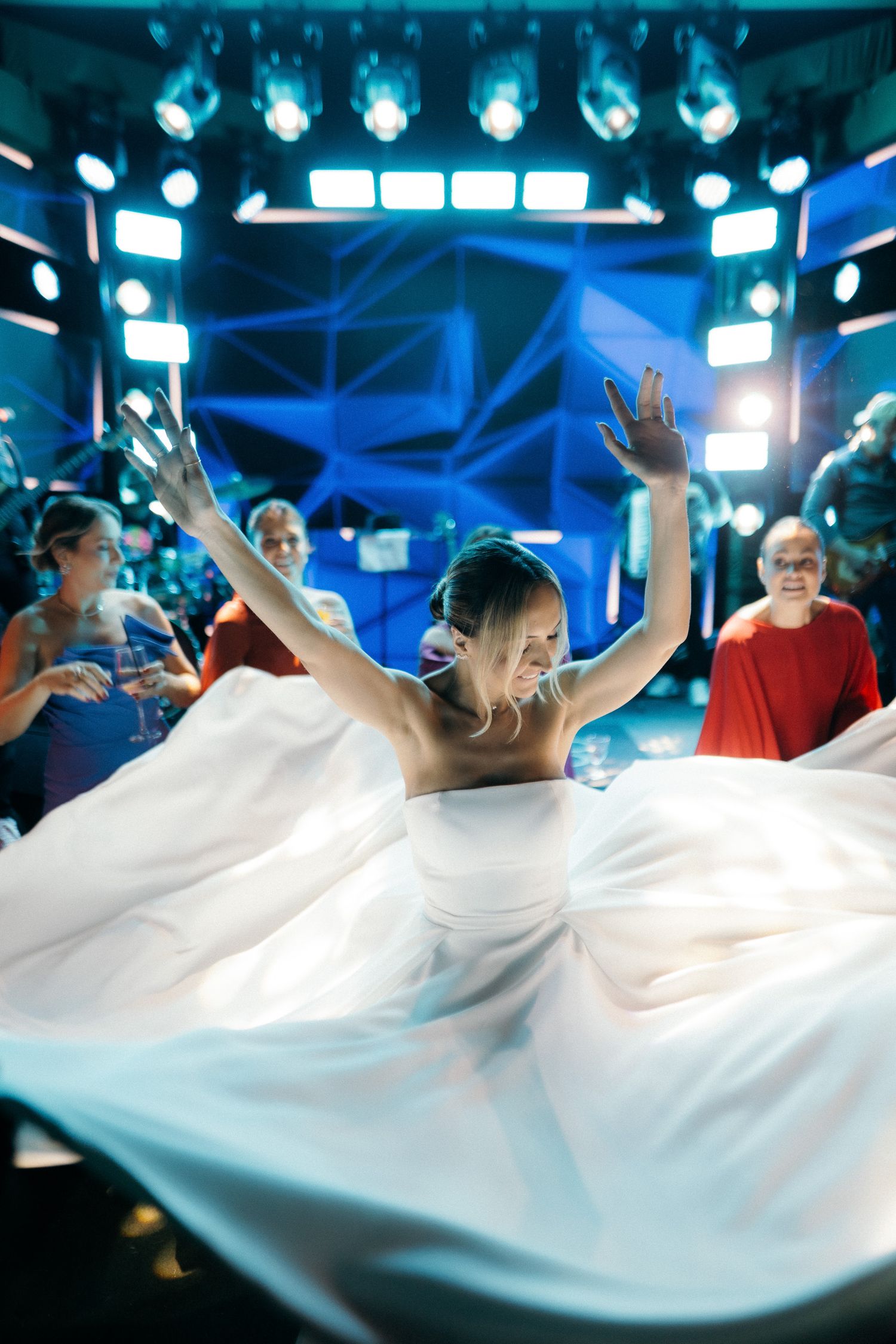 Bride twirls in a stunning white ball gown on the dance floor at her wedding reception.