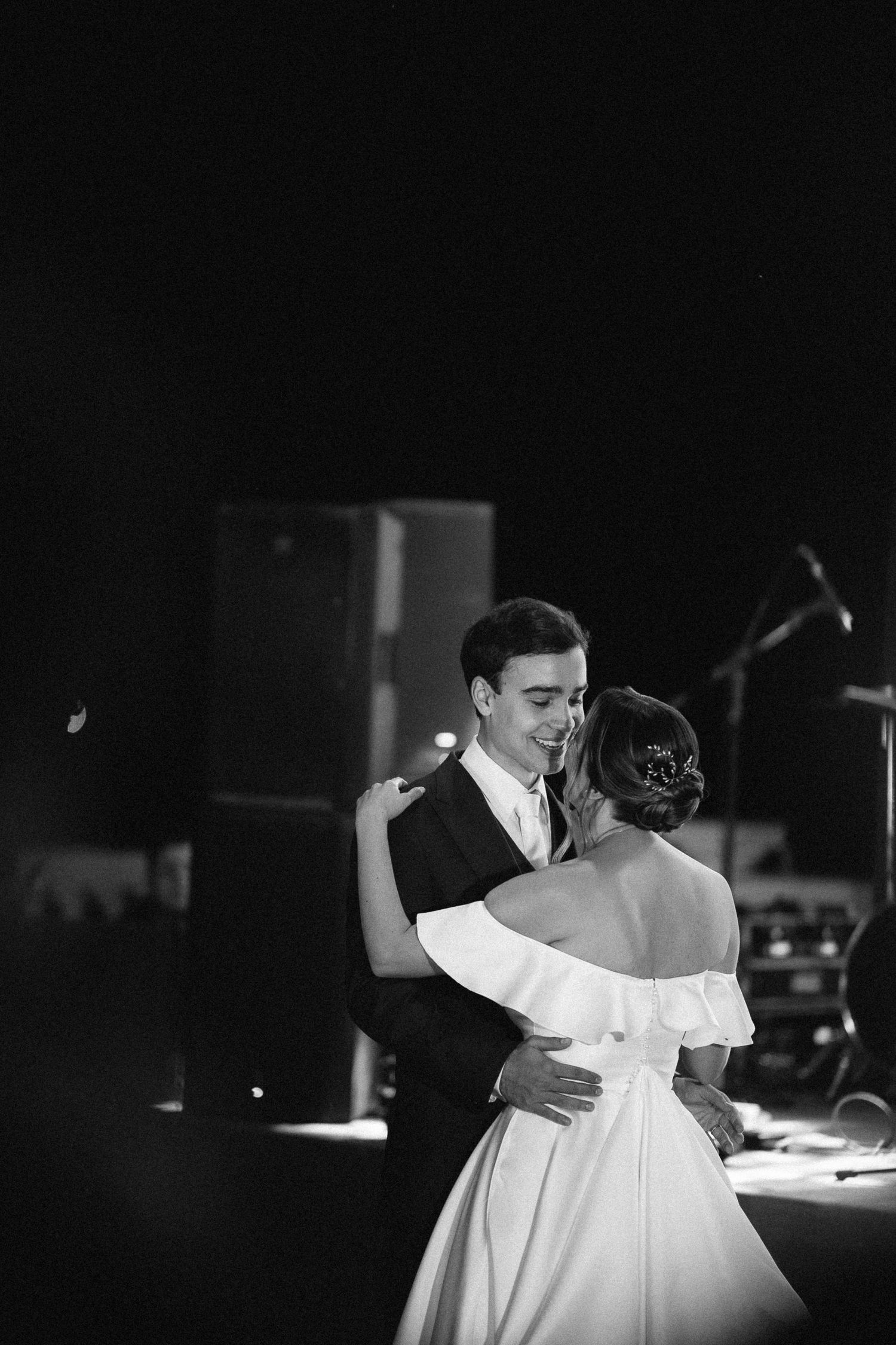 Black and white photo of bride and groom sharing their first dance at wedding reception.