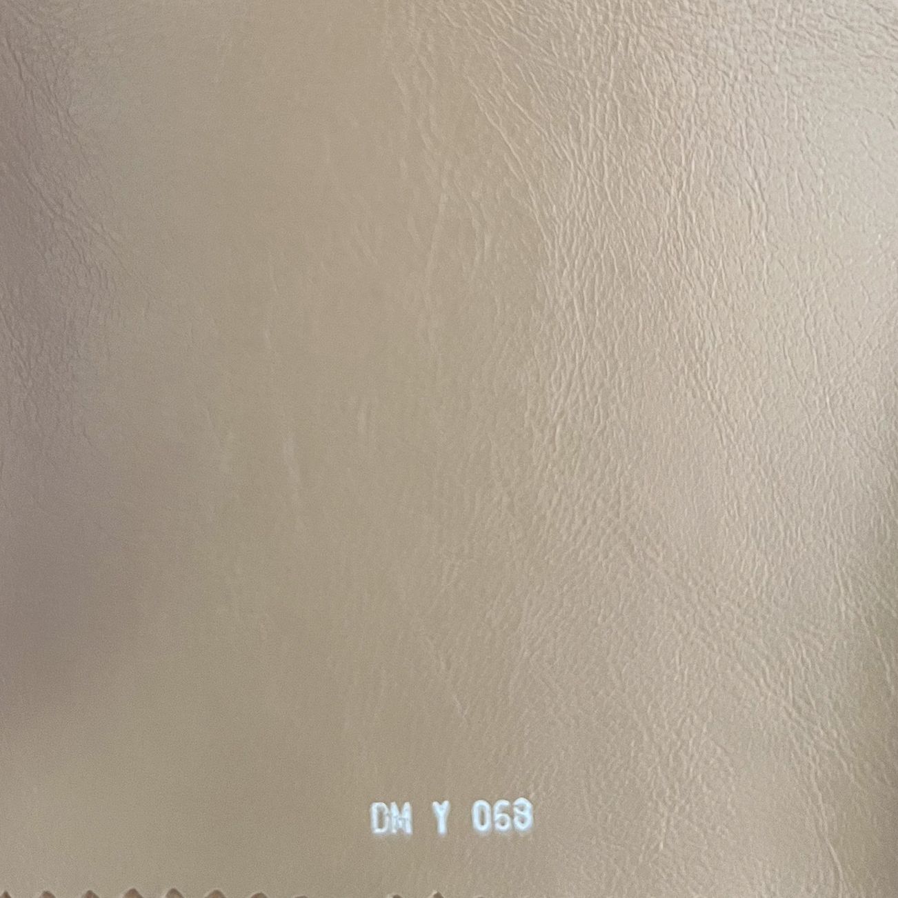 Beige leather fabric swatch with soft grain texture, labeled DM Y 068.