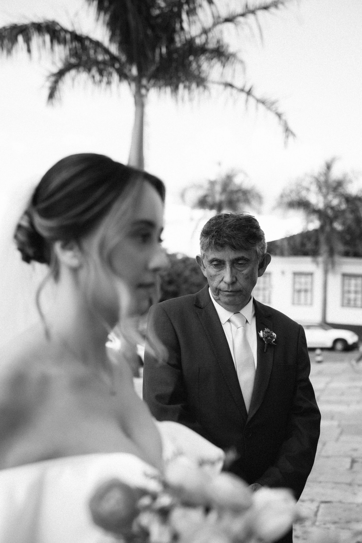 Black and white photo of emotional father watching his daughter the bride before walking her down the aisle.