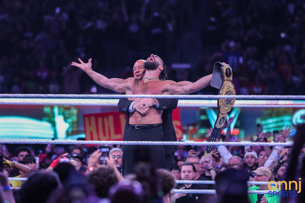 WWE champion raises arms triumphantly holding title belt in the ring at SummerSlam.