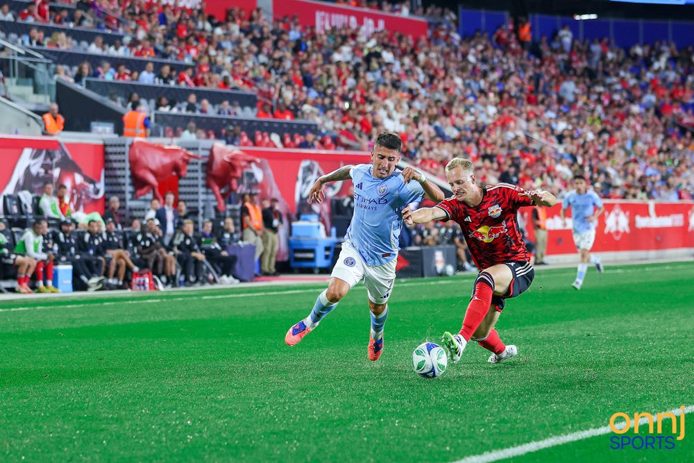 Two soccer players battle for possession of the ball during an MLS regular season match.