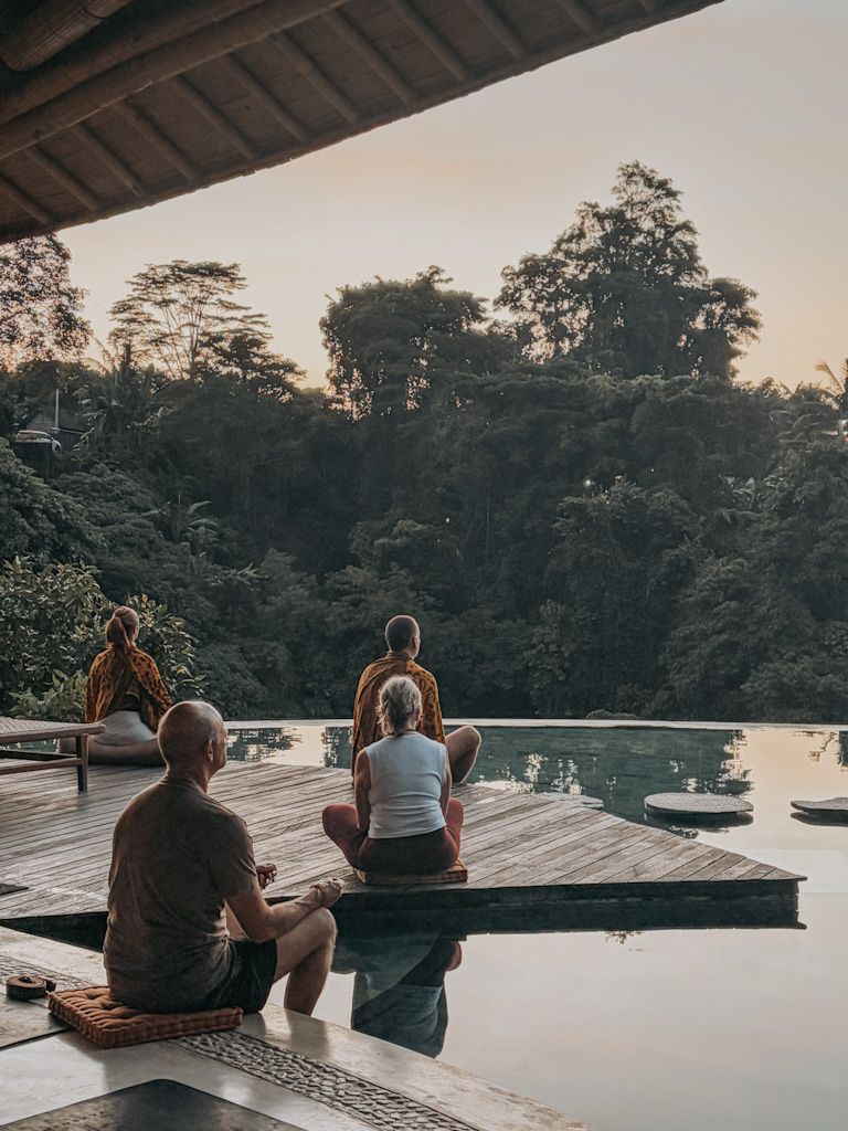 Guests meditating beside the pool during a Bali retreat with Ali Mayfield