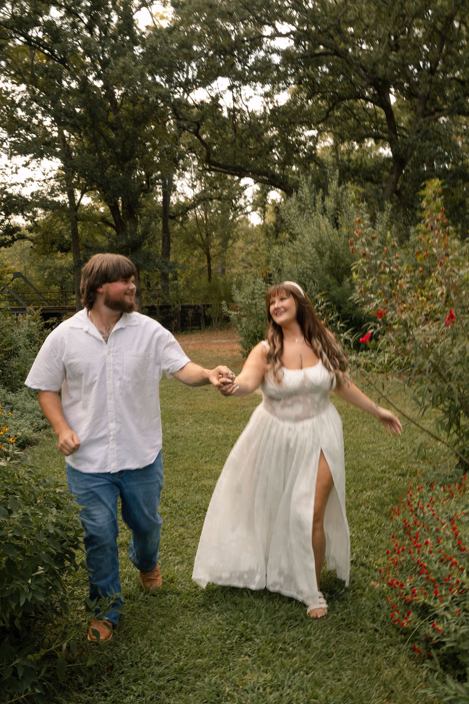 Happy couple walking hand in hand through a beautiful garden on their wedding day.
