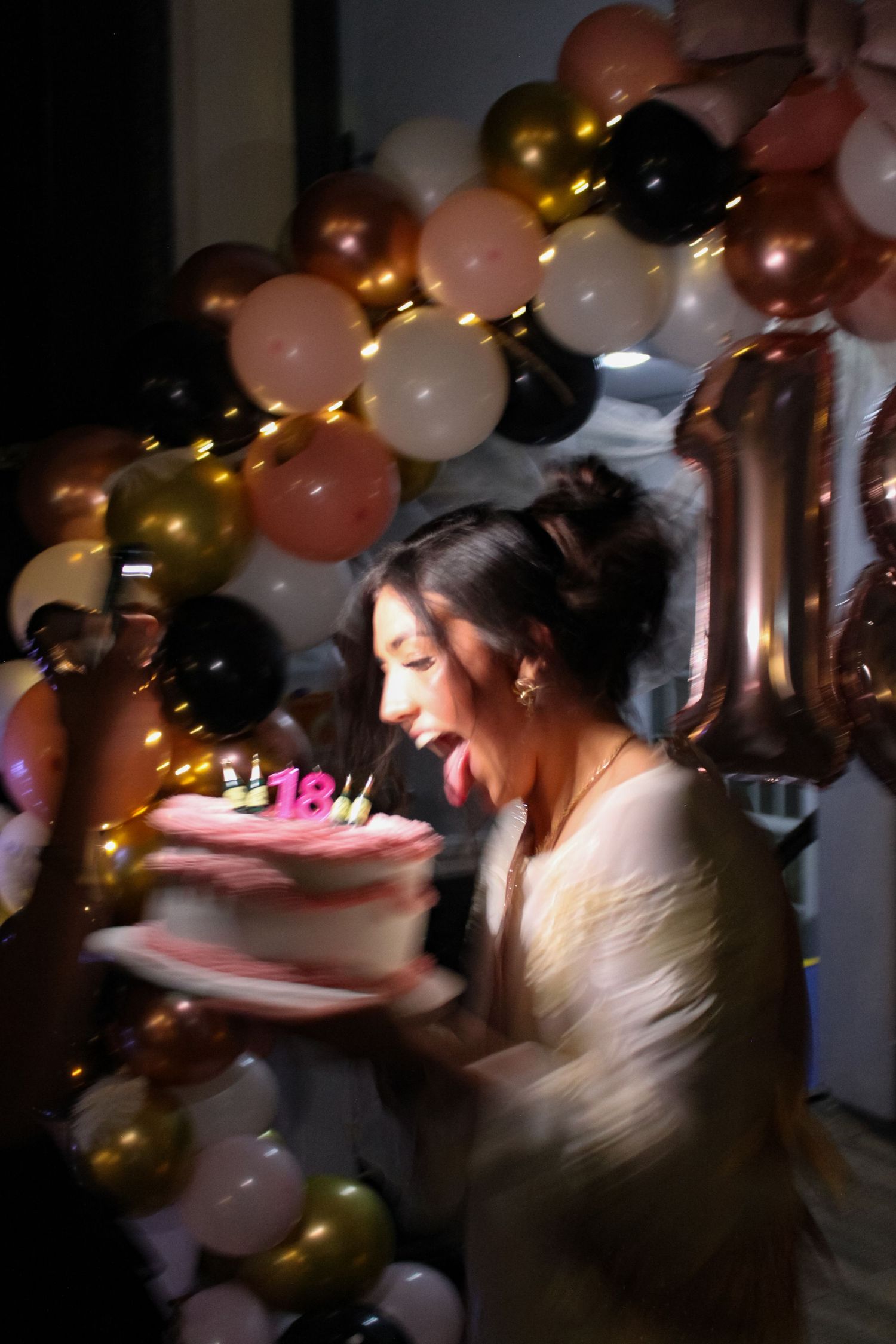 A portrait photo the birthday girl and her cake at an 18th Birthday party.