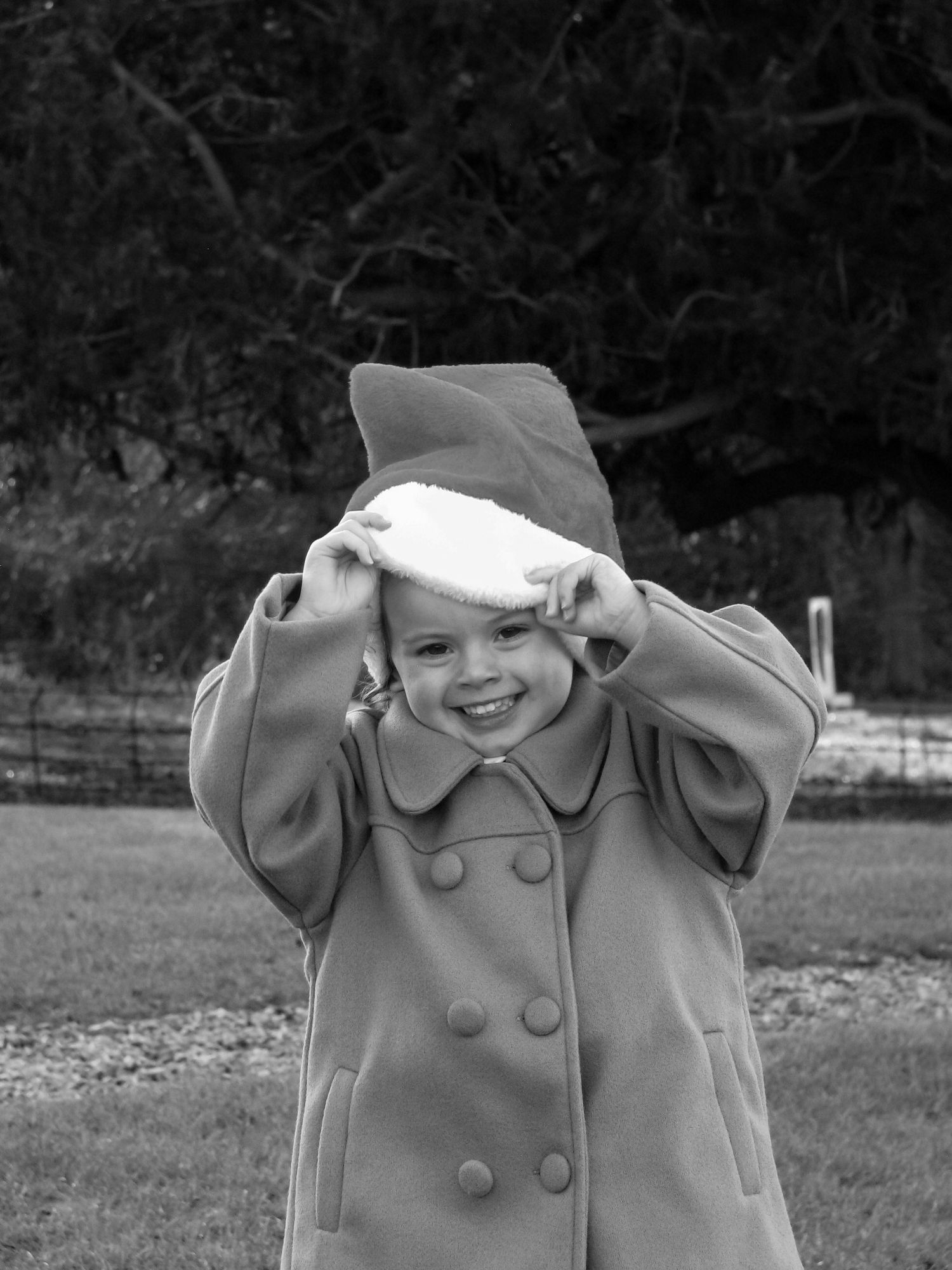 Child wearing a Santa hat and laughing. Family photoshoot. Black and white.