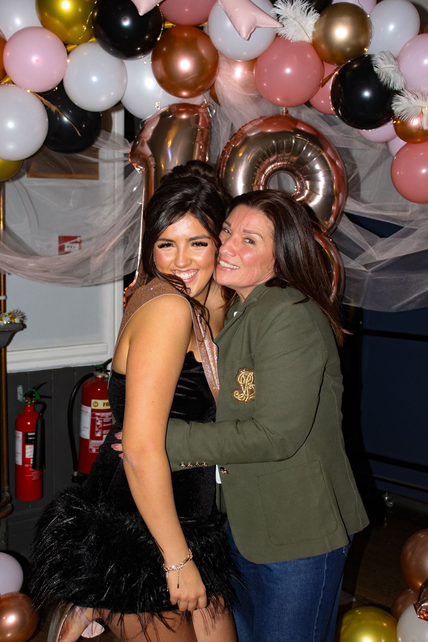 A portrait photo of two women hugging at an 18th Birthday party.