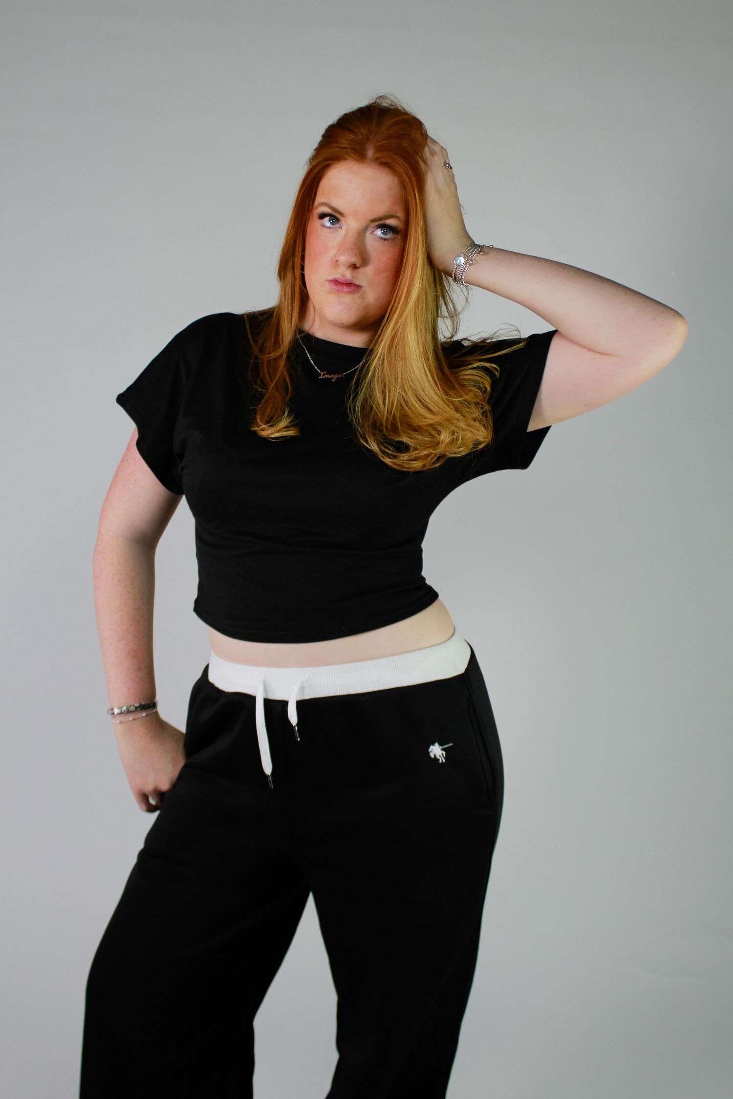 Studio portrait of a woman posing. Fashion photo. Wearing a black and white tracksuit.