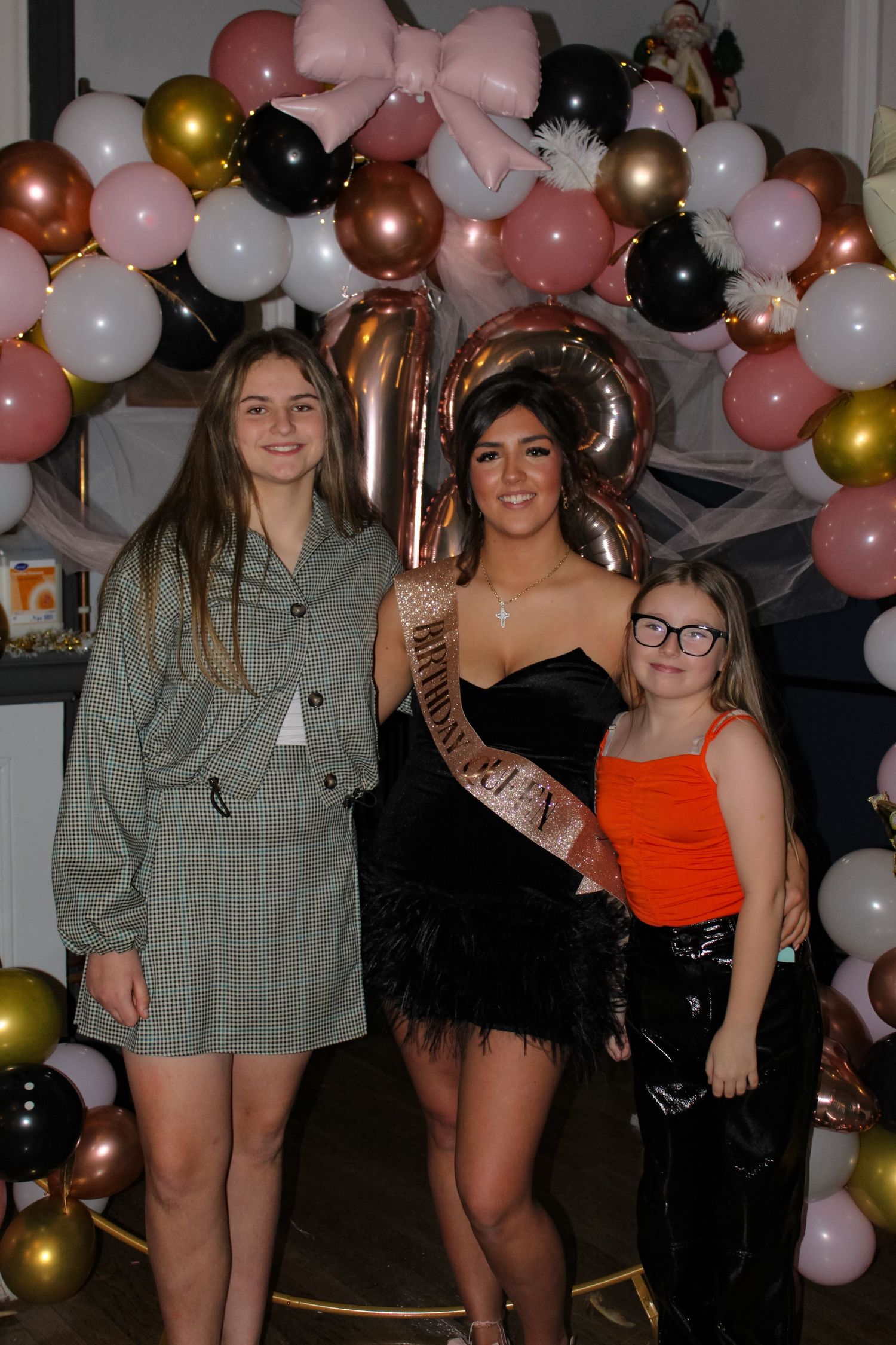 A portrait photo of three women hugging at an 18th Birthday party.