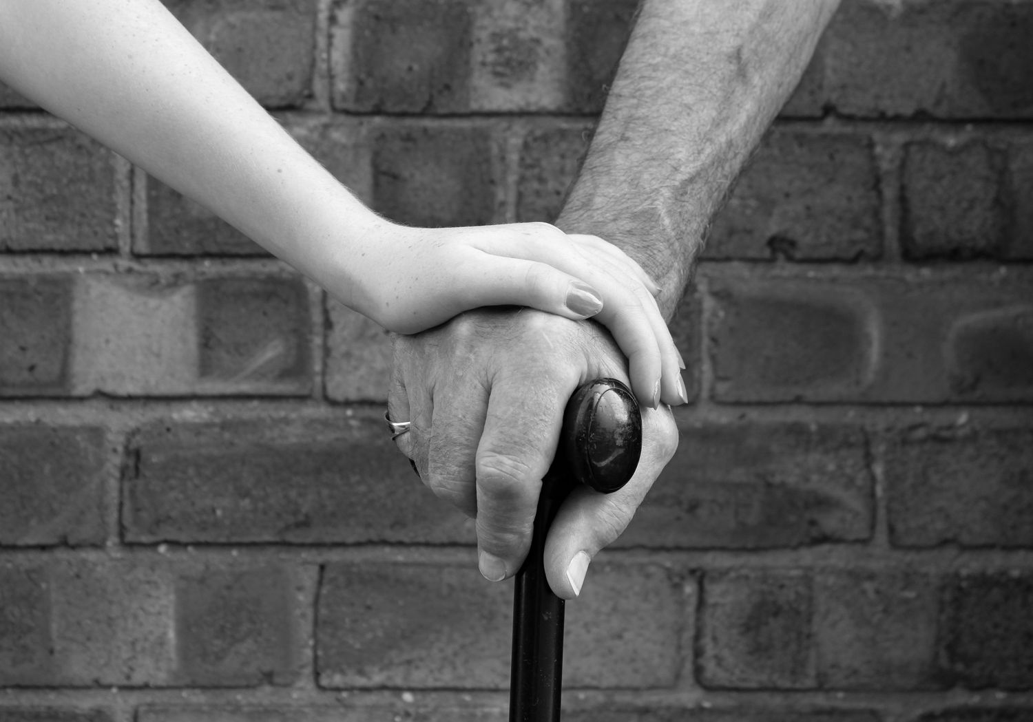 A grandparent and grandchild holding hands. Black and white.