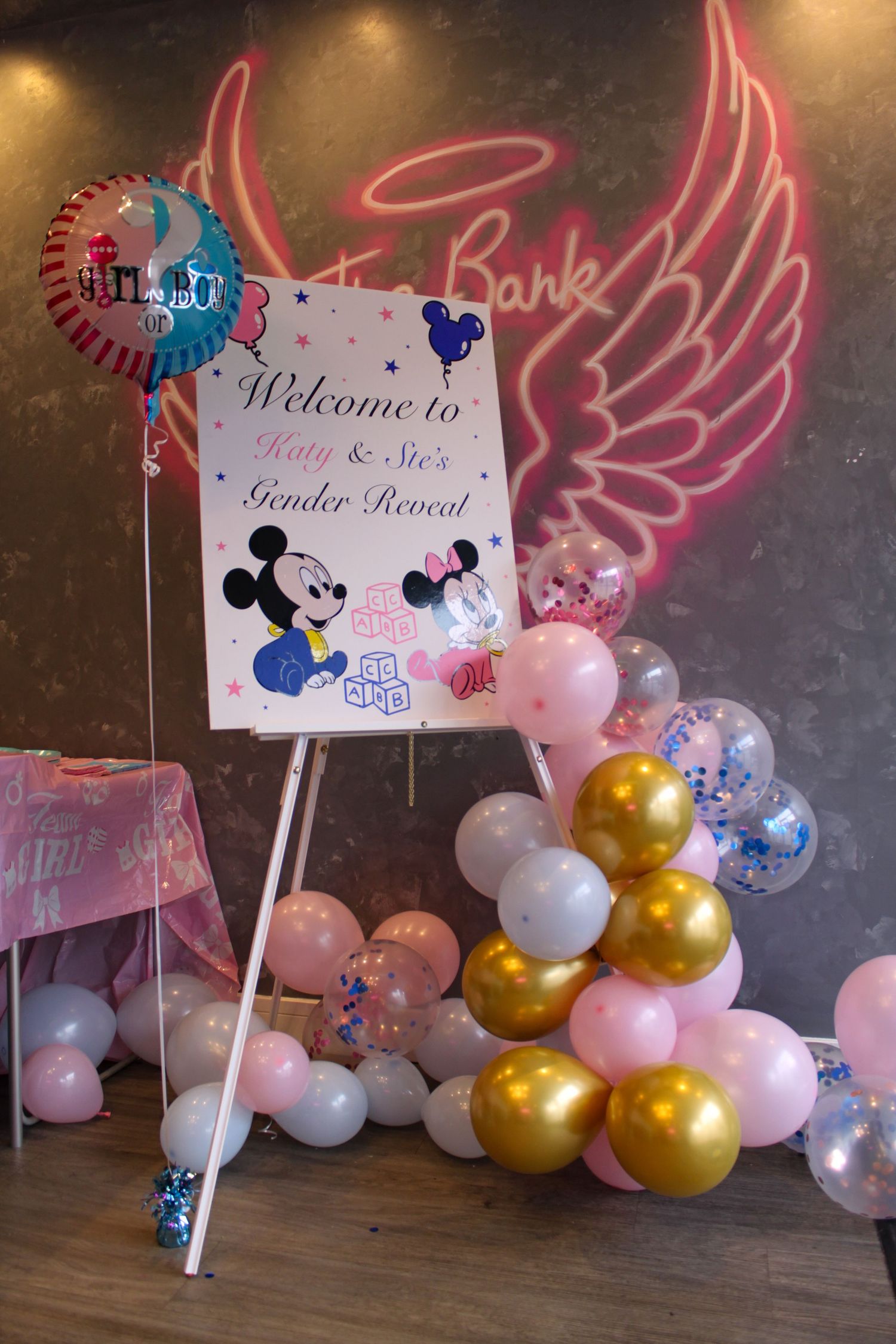 A sign at a gender reveal party with balloons around it.