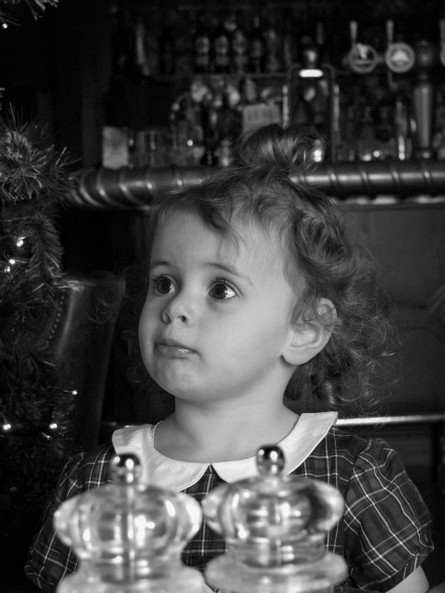 Child looking at her father who is off camera. Family photoshoot. Black and white.