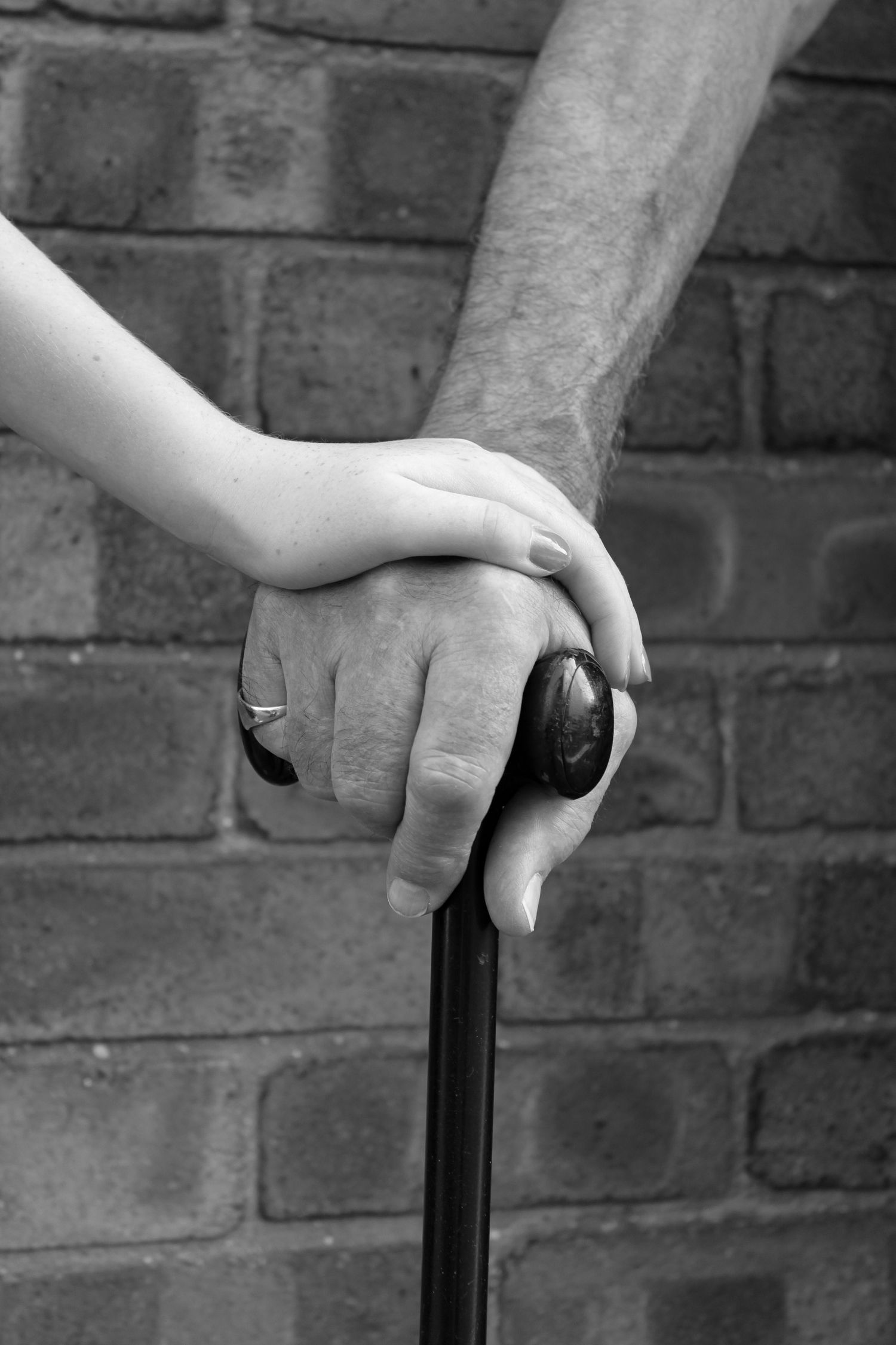 Photo of a grandparent and grandchild holding hands. Black and white.