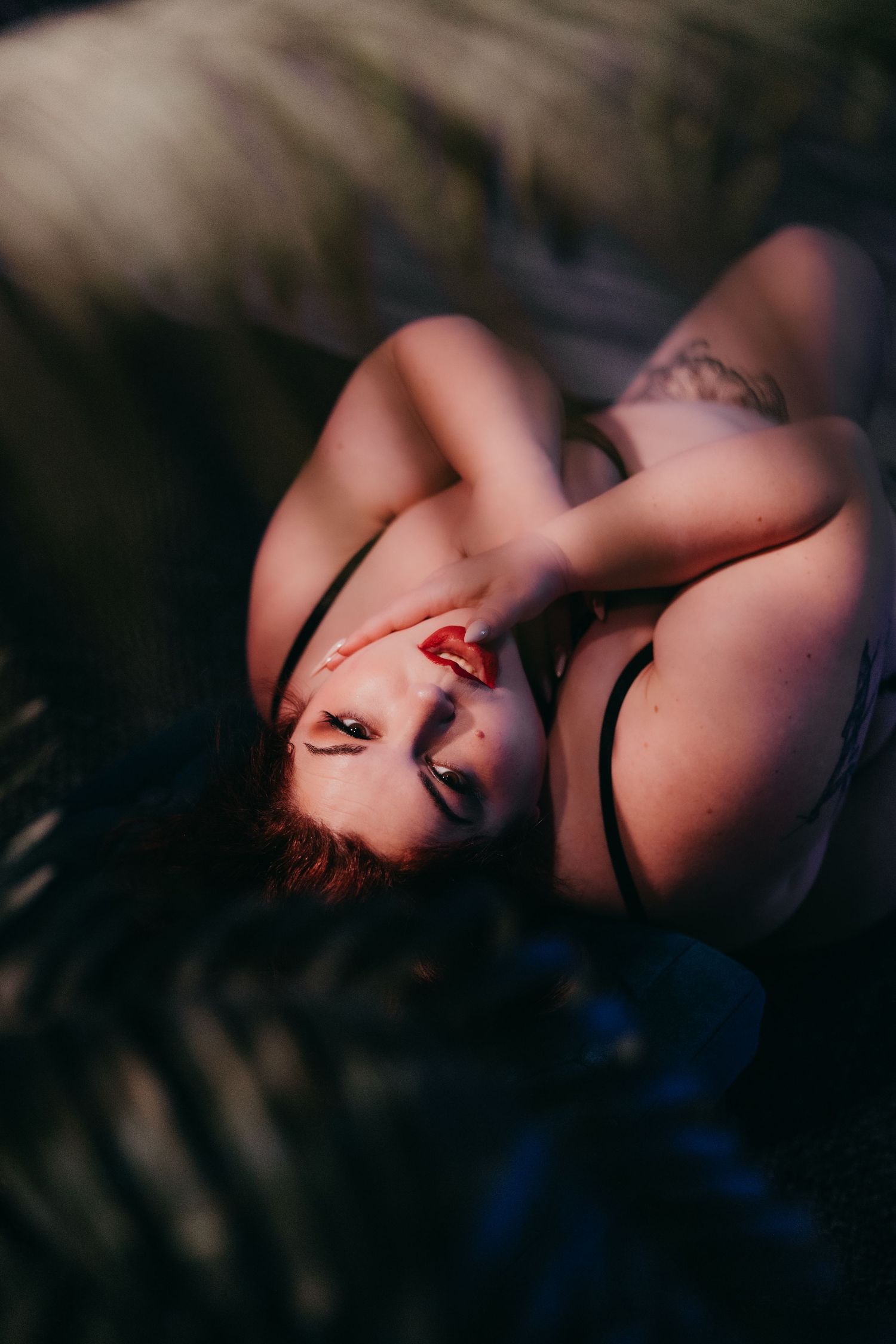 Intimate boudoir photography with soft shadows and dramatic lighting.