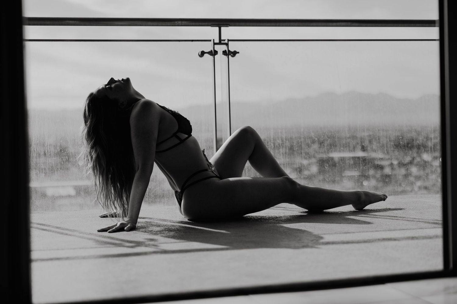 Dramatic black and white silhouette against window backdrop.