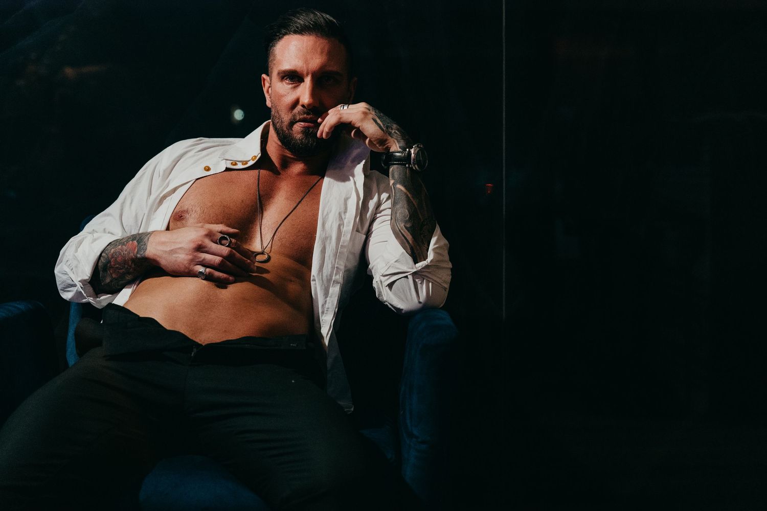 Dramatic portrait photography in dark room with moody lighting.