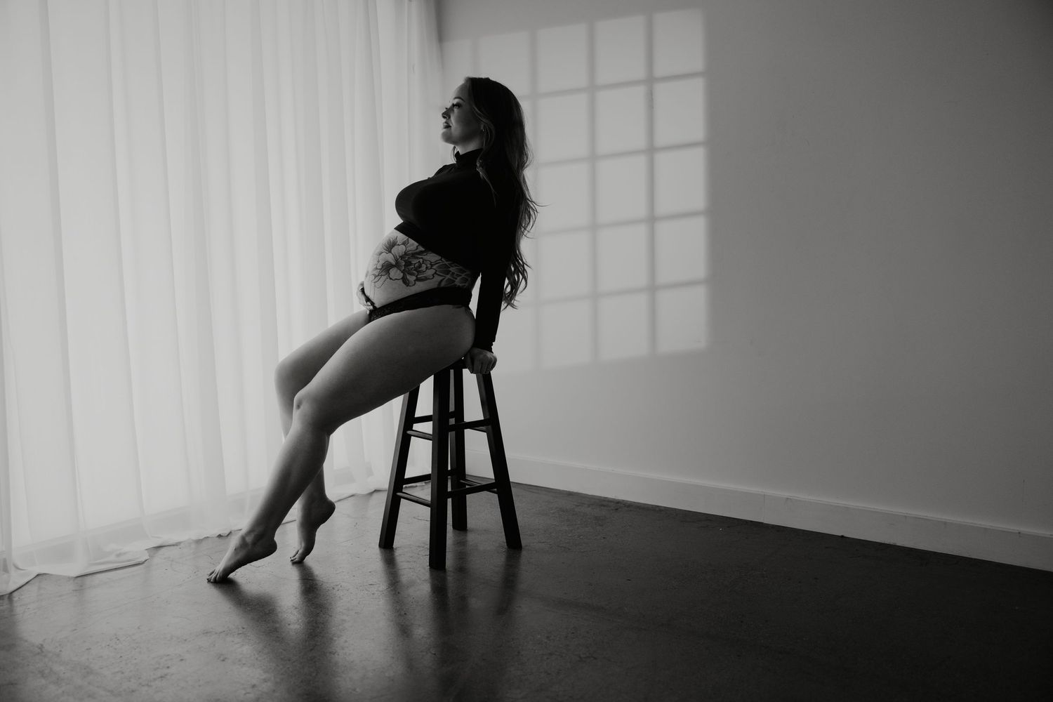 Black and white photo series showing a person in motion while interacting with a wooden chair in an empty room.