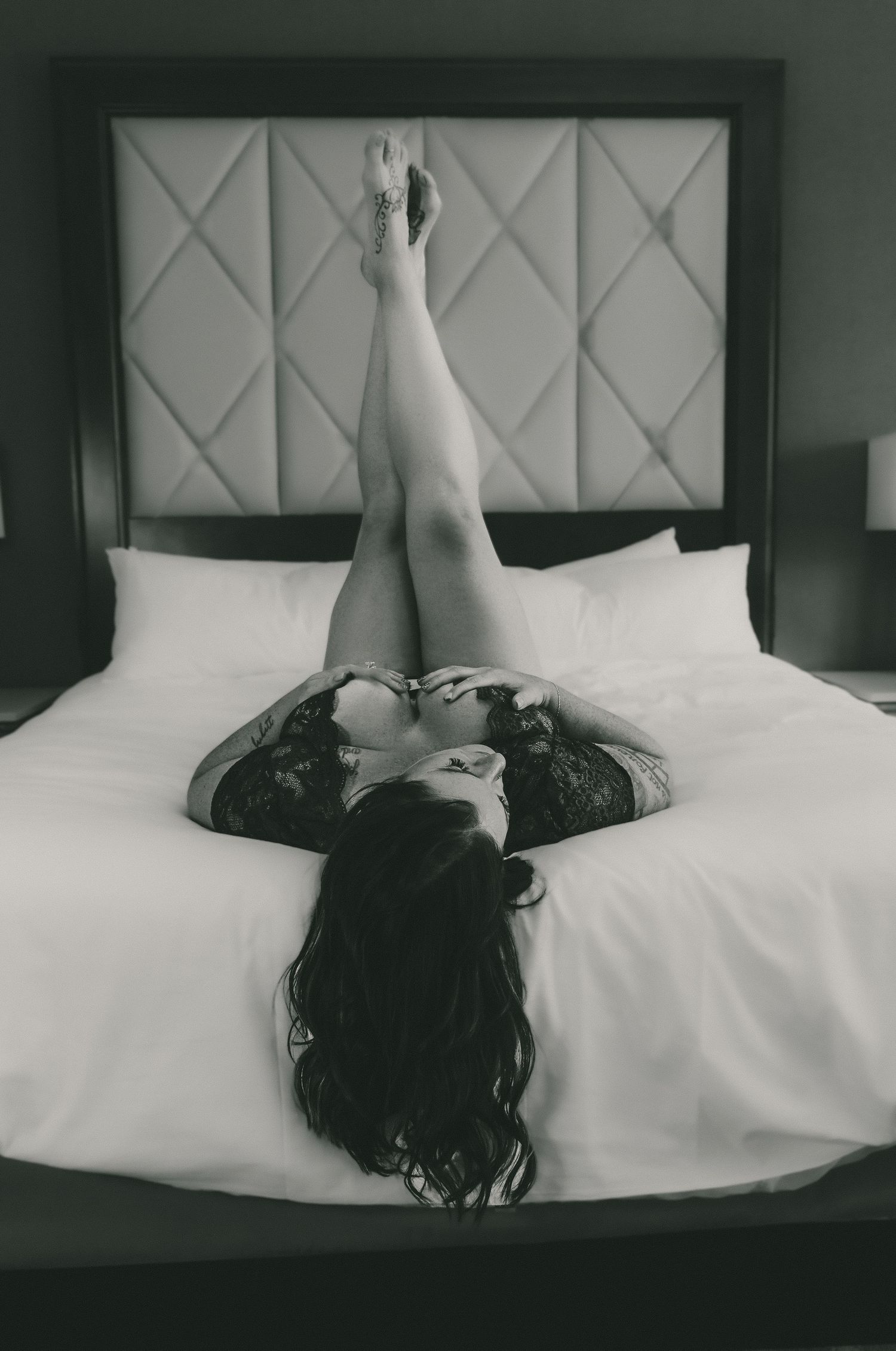 A series of black and white photos showing a figure lying on a white bed with a geometric patterned headboard.