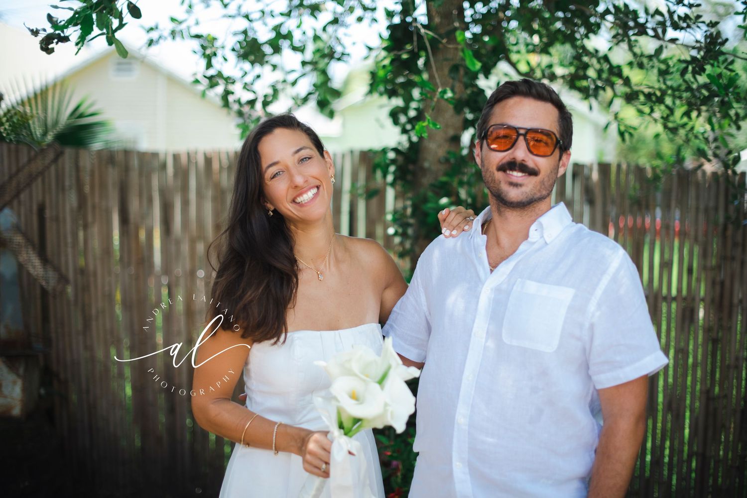 A couple in coordinated white outfits sharing intimate moments in a garden setting.
