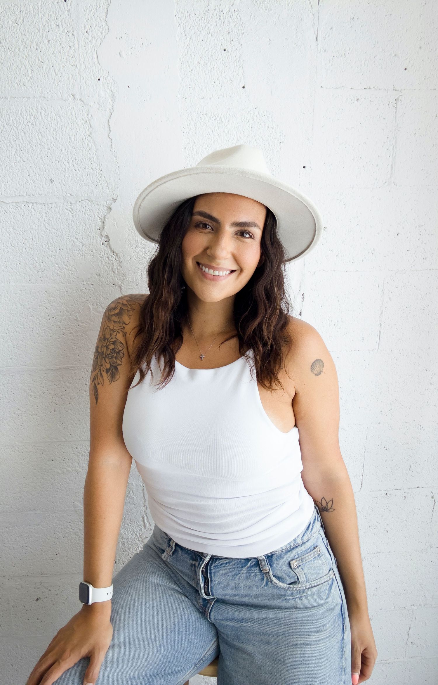 Natural lifestyle portrait featuring white tank top and light denim styling.