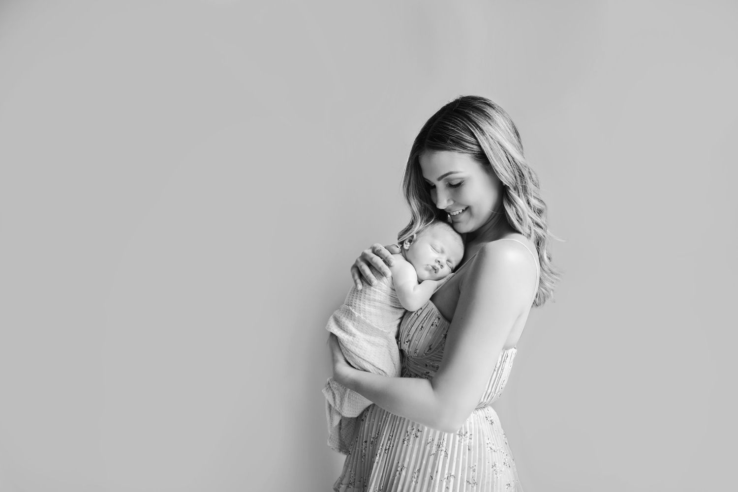 Black and white photo series showing tender moments between a mother and her newborn baby.
