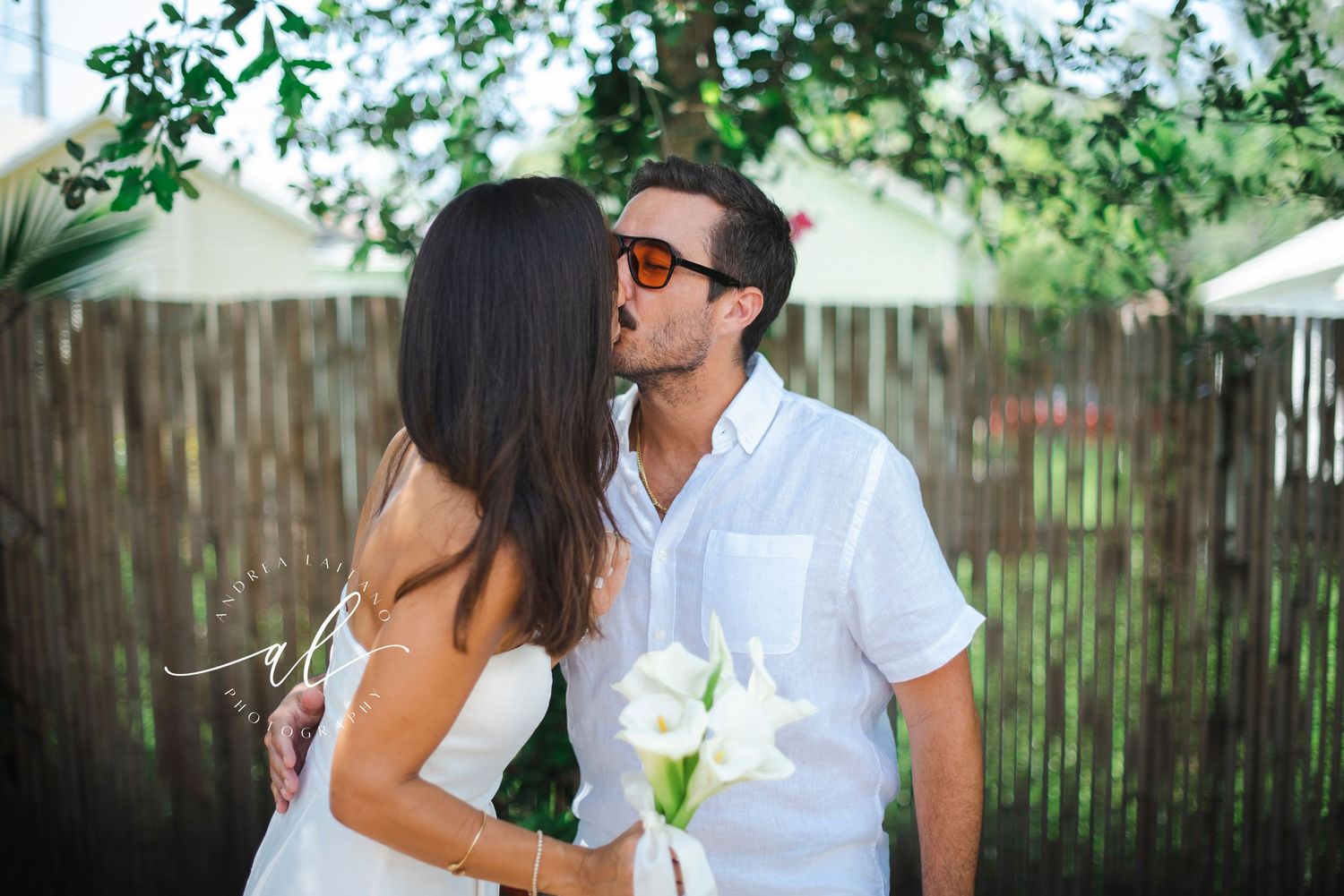 Recently married couple first kiss in garden.