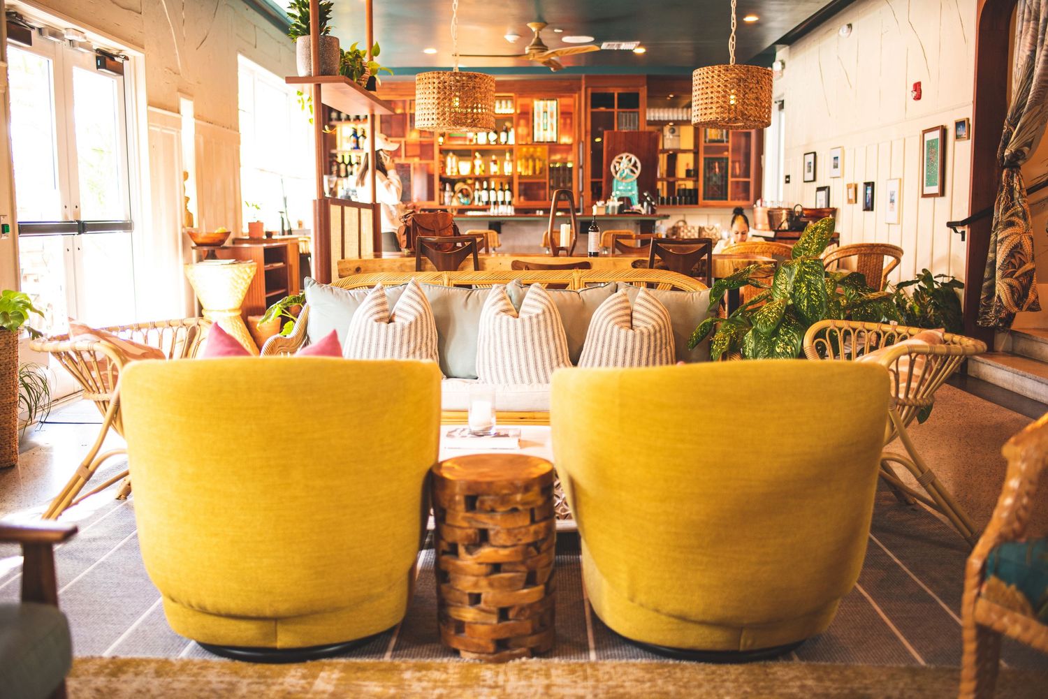 Cozy restaurant interior with yellow chairs, warm lighting, and rustic decor creates an inviting dining atmosphere.