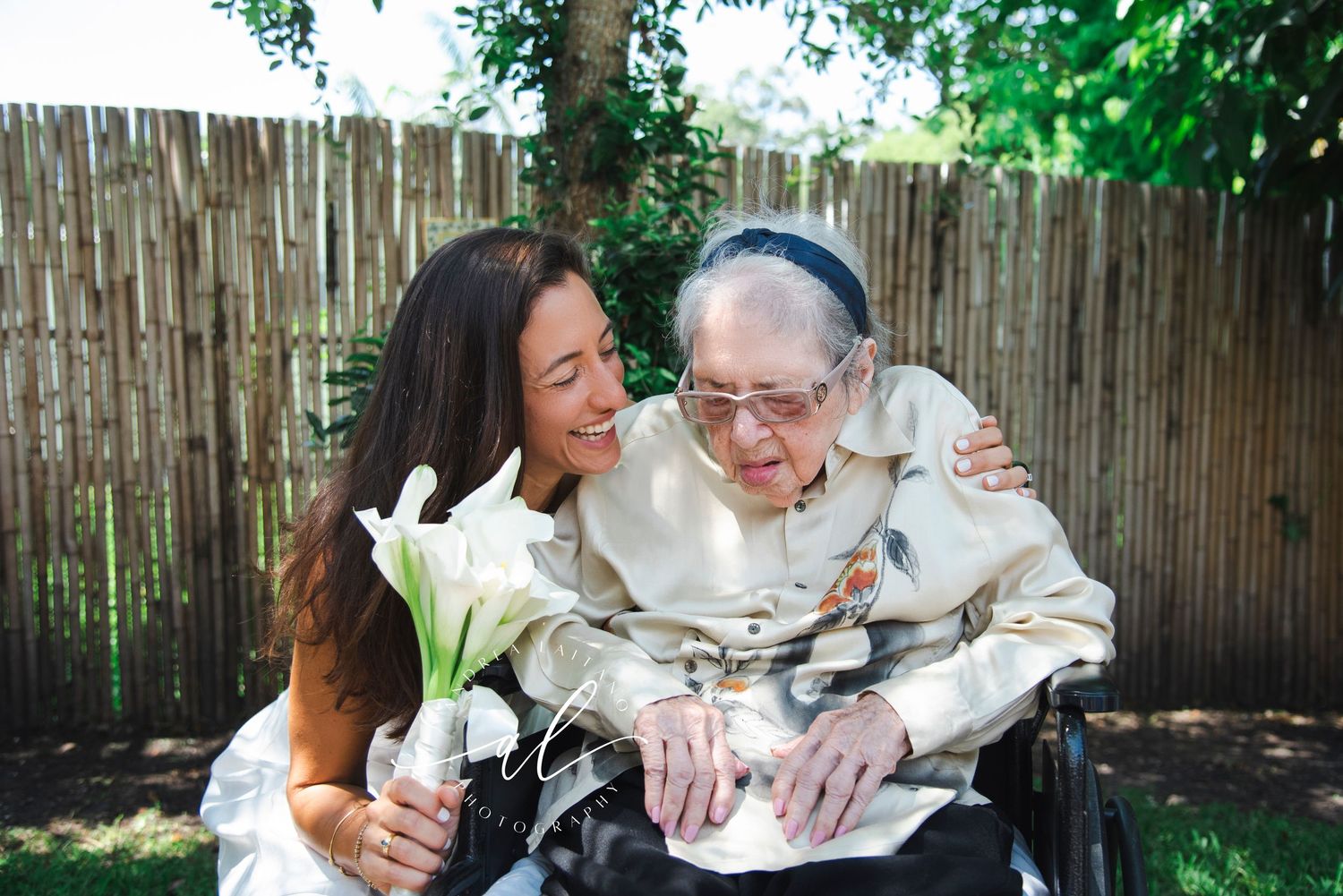 A couple sharing laughter and embraces in a garden with bamboo fencing.