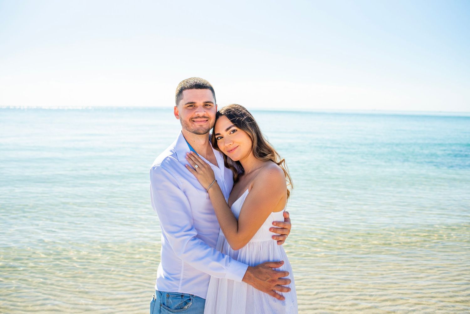 A couple shares a romantic moment together on a beautiful tropical beach with crystal clear turquoise waters.