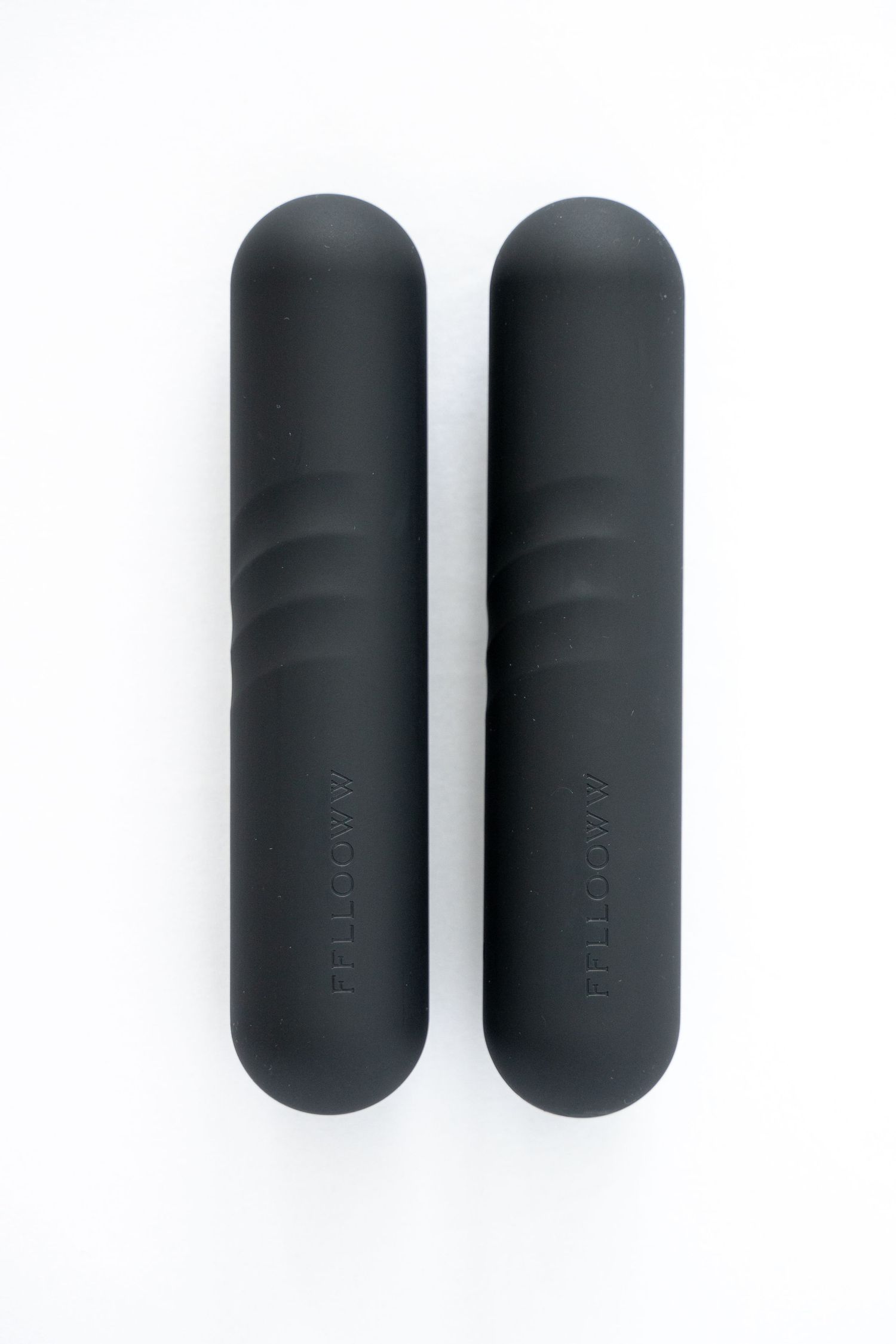 Two matte black cylindrical objects displayed on white background.