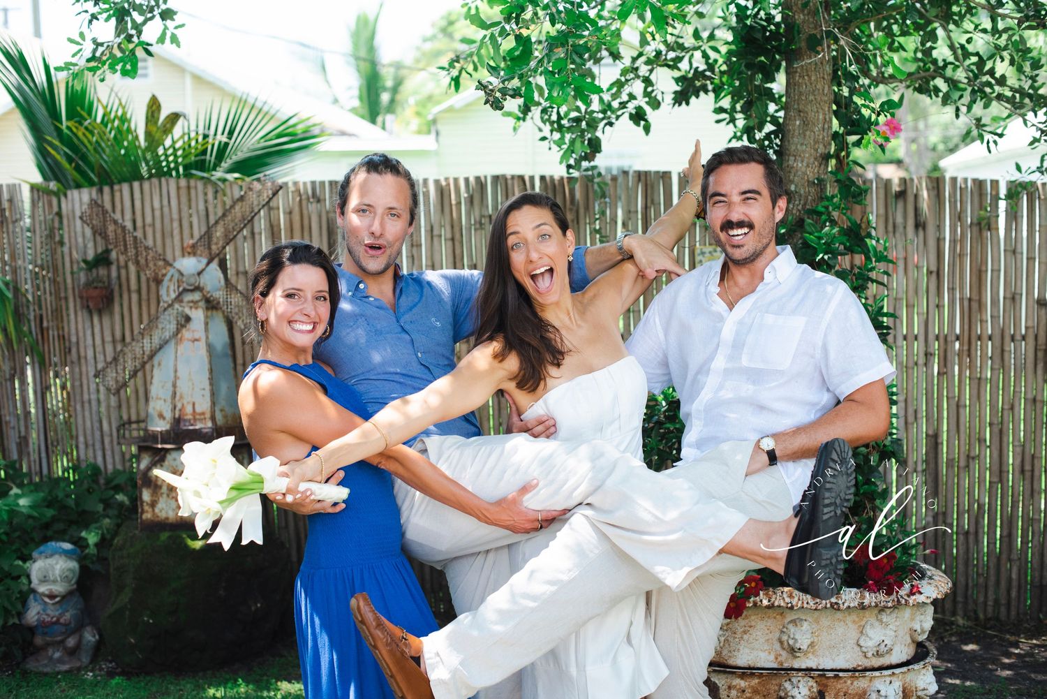 Wedding guests laugh and celebrate as couple engages in cake smashing tradition.