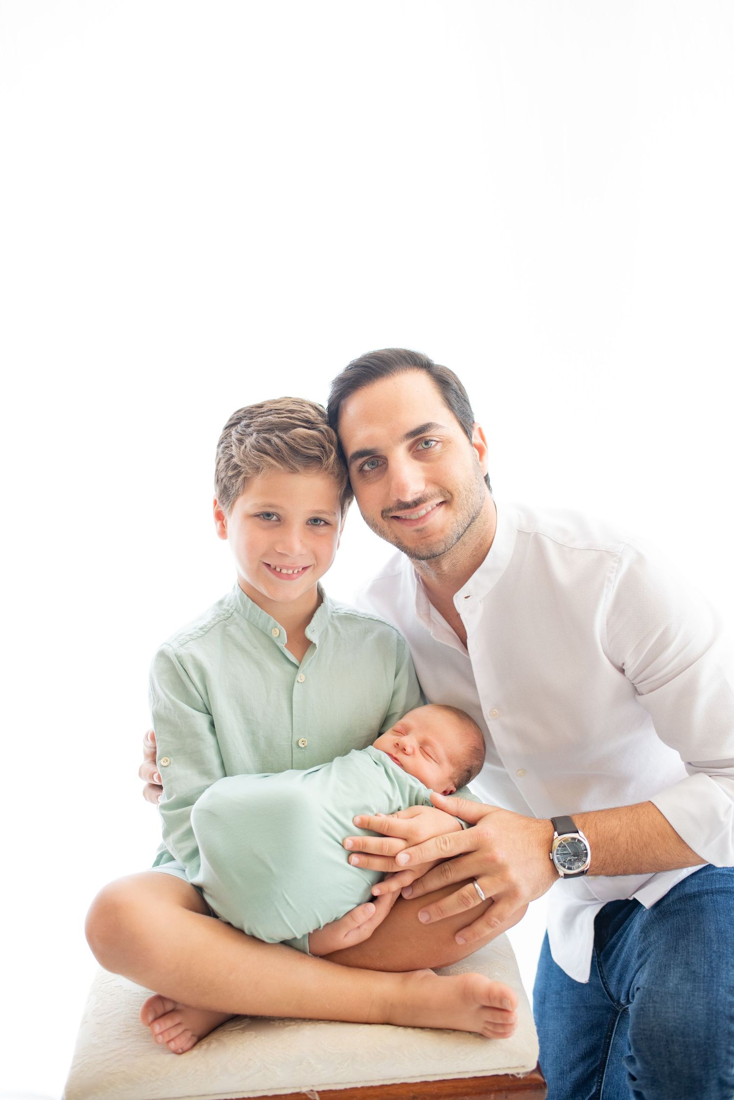 Family portrait featuring tender moments in coordinated white and mint green outfits.