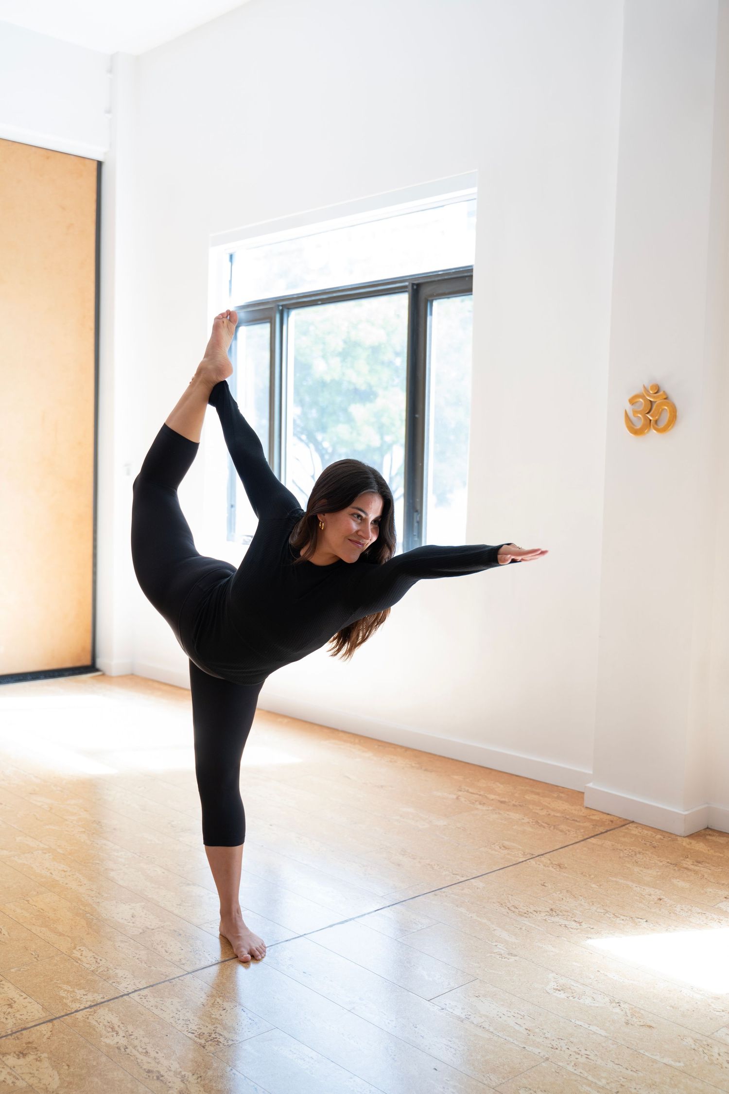 Yoga practitioner demonstrates a graceful standing split sequence in a bright, minimalist studio space.