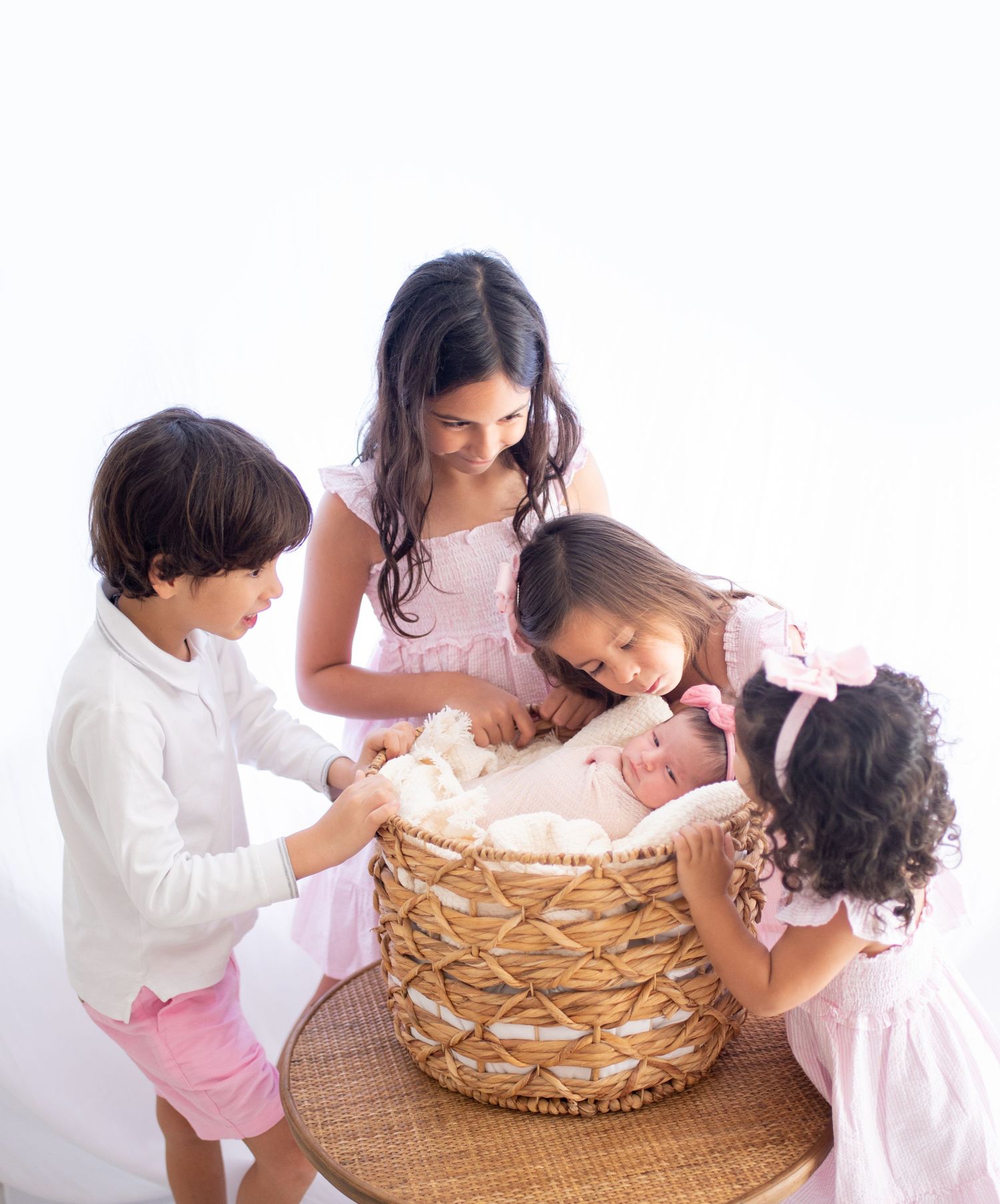 A sequence of photos showing a family playing with a white bunny in a woven basket against a bright background.