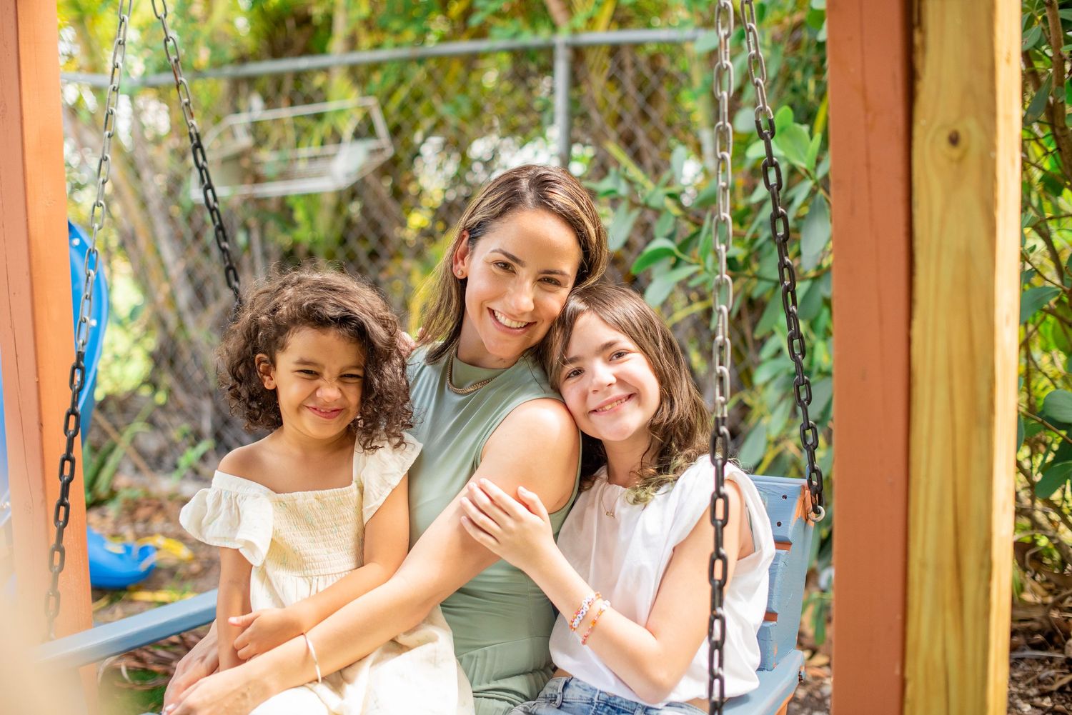 A group enjoys a fun afternoon together on wooden swings in a sunny outdoor setting.